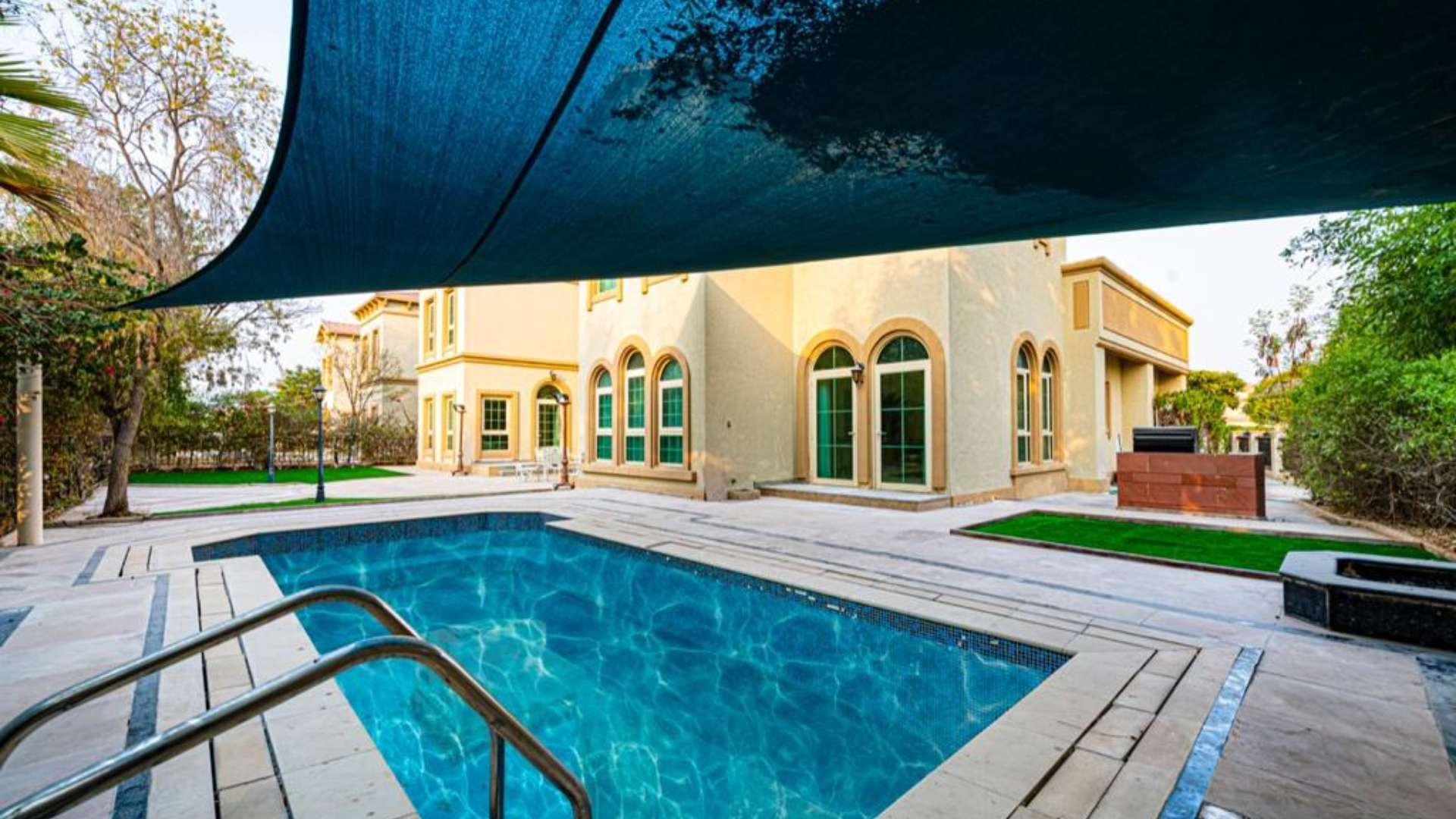 Alt text: "Jumeirah Islands villa view with city skyline and lush greenery at sunset.",Luxurious 6-bedroom villa with private pool in Jumeirah Islands, Cluster 05 for short-term rent