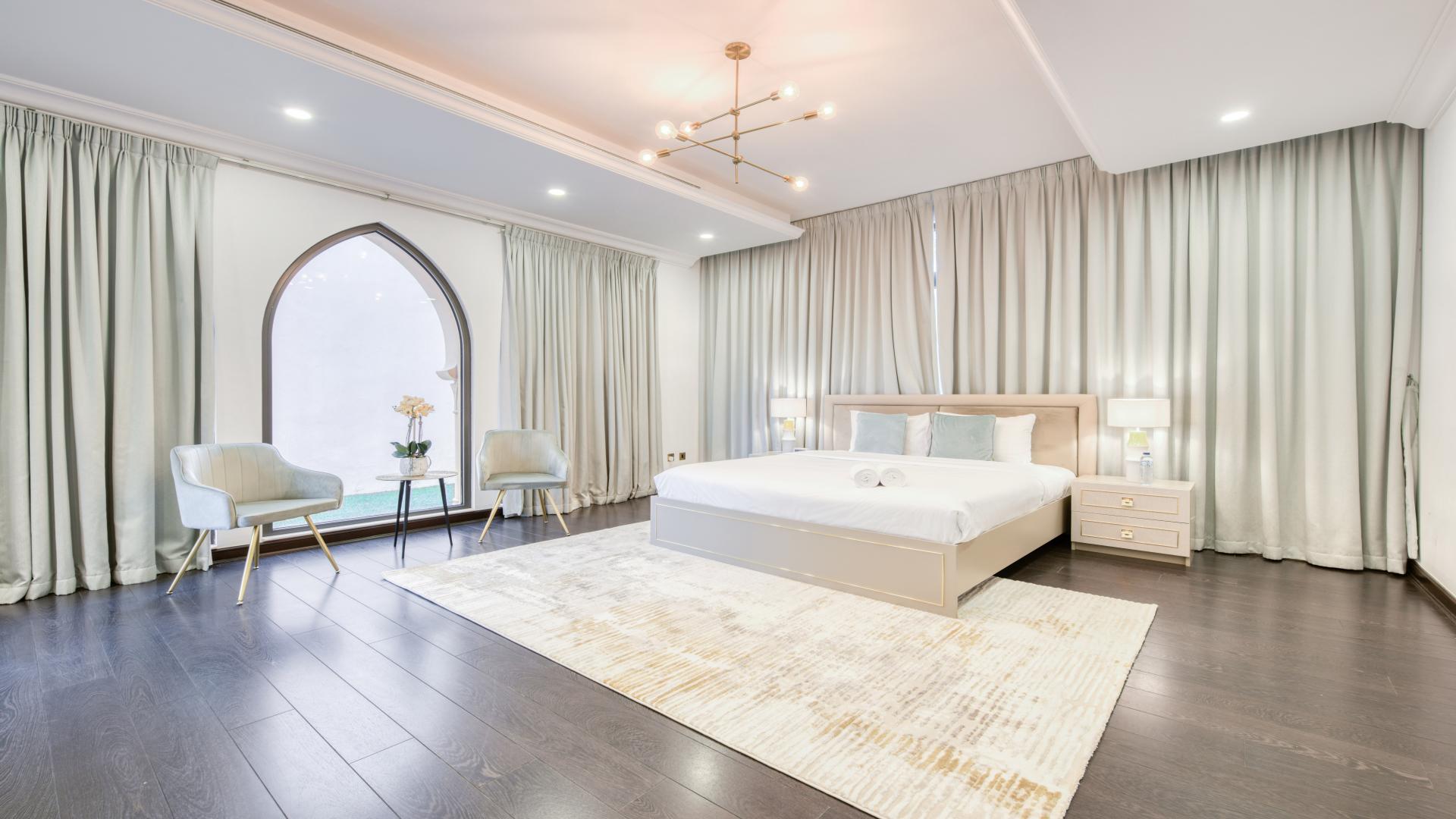 "View from villa balcony in Palm Jumeirah's Garden Homes, showcasing luxury neighborhood landscape.",Luxury bedroom in modern Palm Jumeirah villa, featuring elegant furnishings and stylish decor