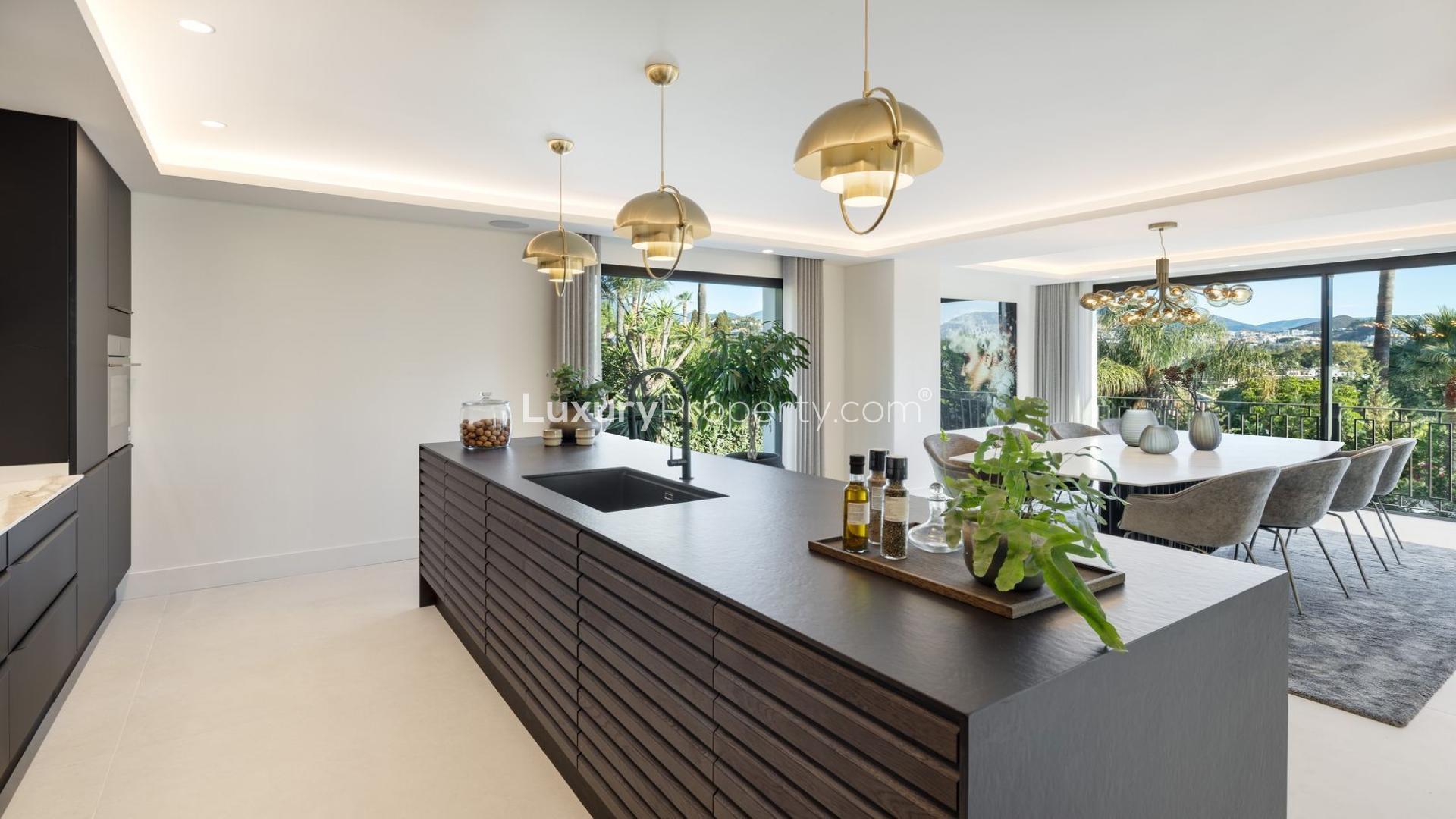 "Modern villa with pool at sunset in Nueva Andalucía, Marbella, 5-bedroom luxury property.",Modern kitchen and dining area in Las Brisas Marbella villa, Nueva Andalucía