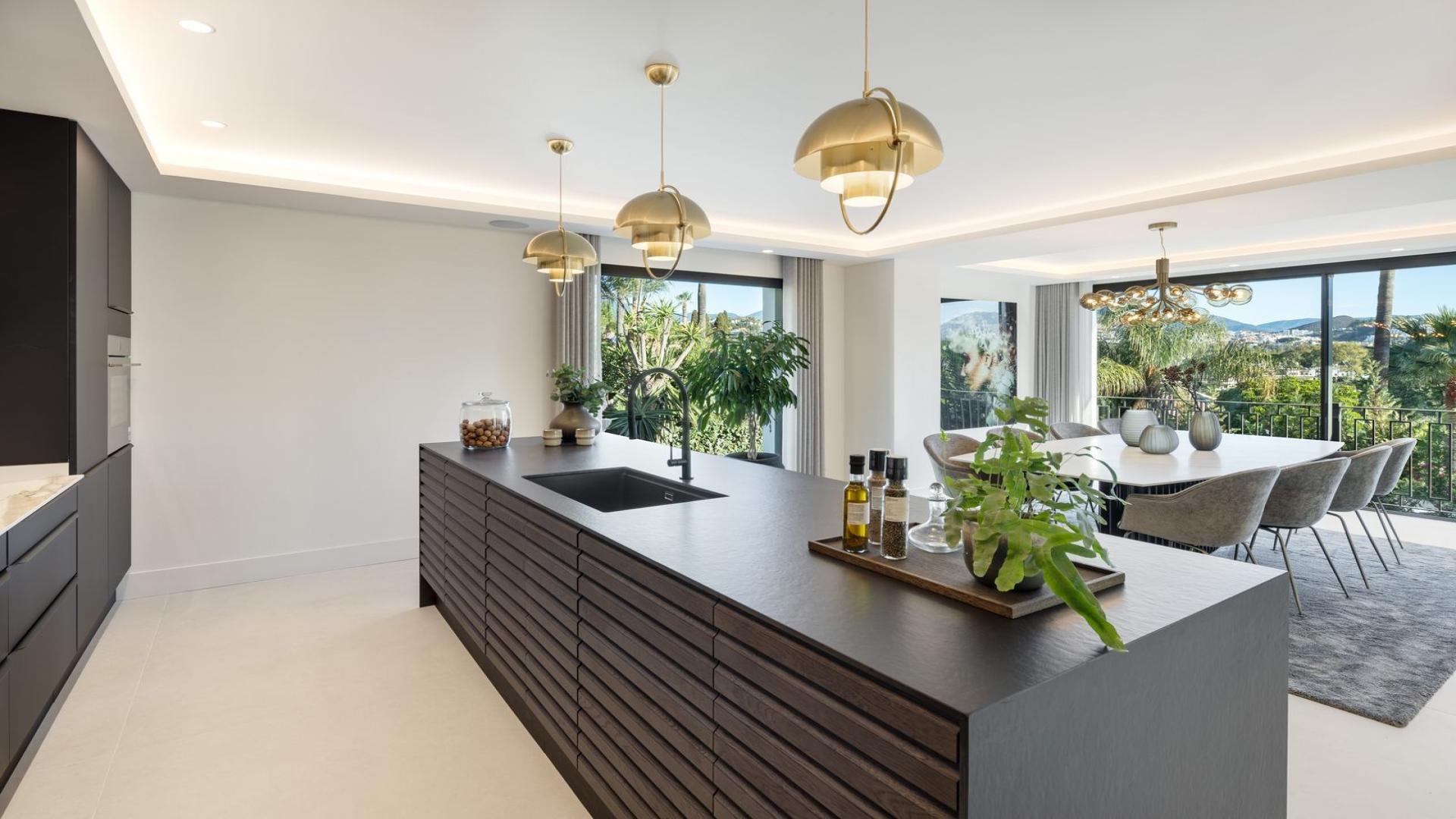 "Modern villa with pool at sunset in Nueva Andalucía, Marbella, 5-bedroom luxury property.",Modern kitchen and dining area in Las Brisas Marbella villa, Nueva Andalucía