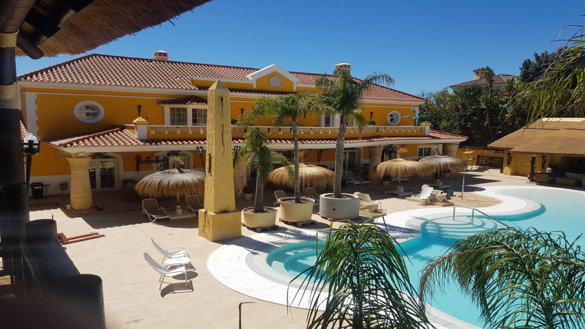 Luxurious 6-bedroom villa entrance with grand columns in Sotogrande, Cadiz, Spain at dusk