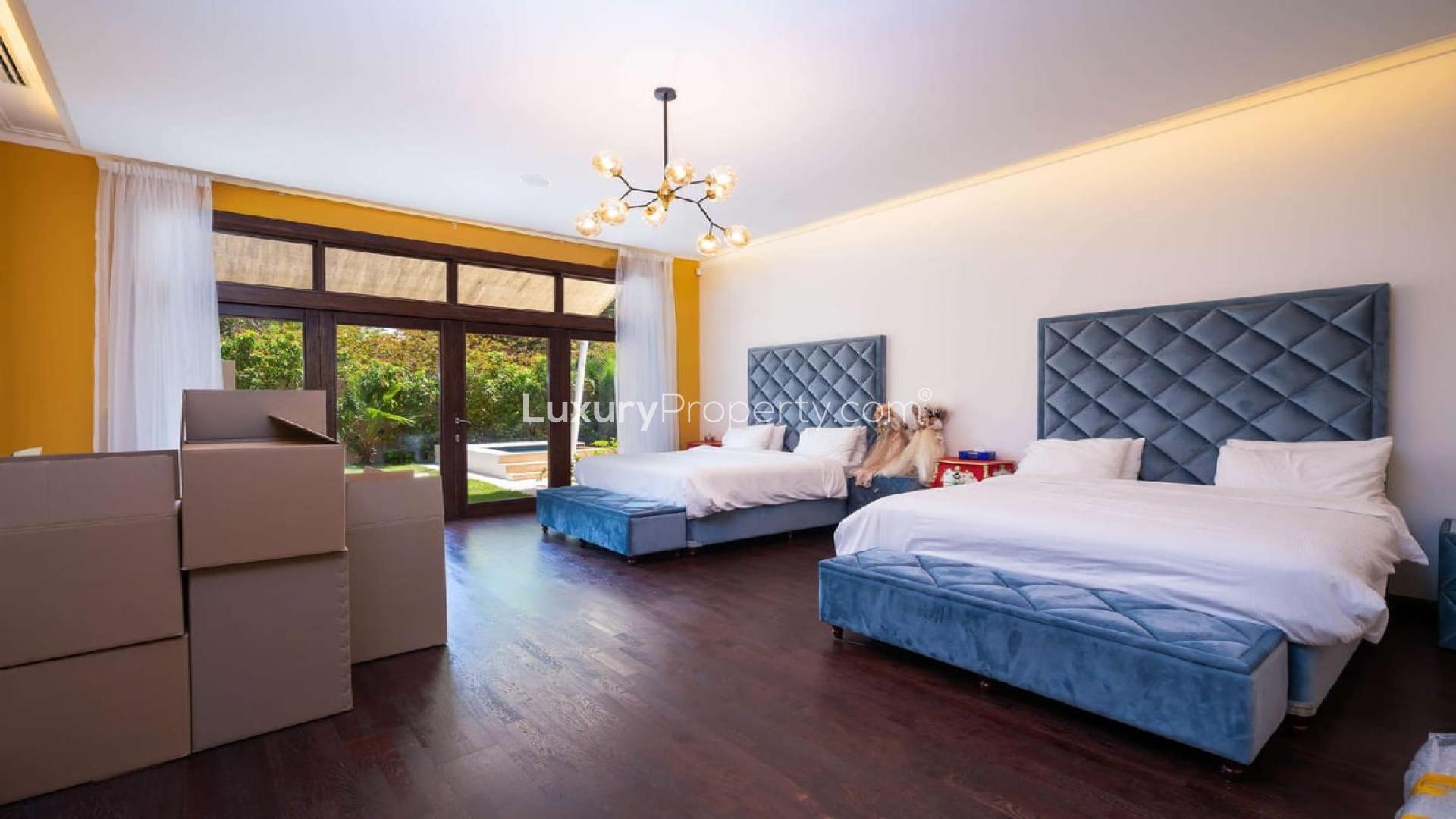 Luxurious Al Barari villa with private pool, sun loungers, and lush garden for rent