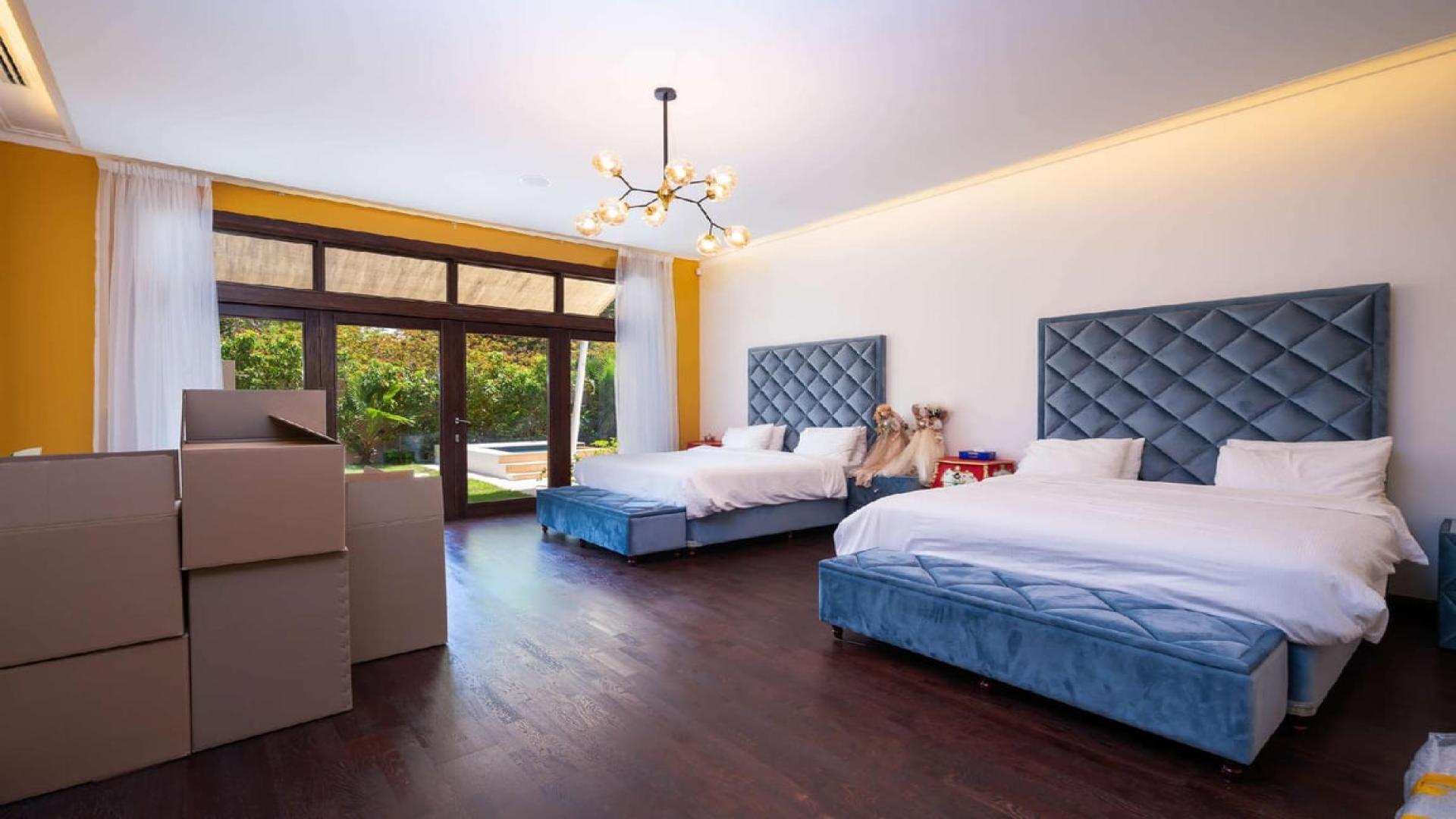 Luxurious Al Barari villa with private pool, sun loungers, and lush garden for rent