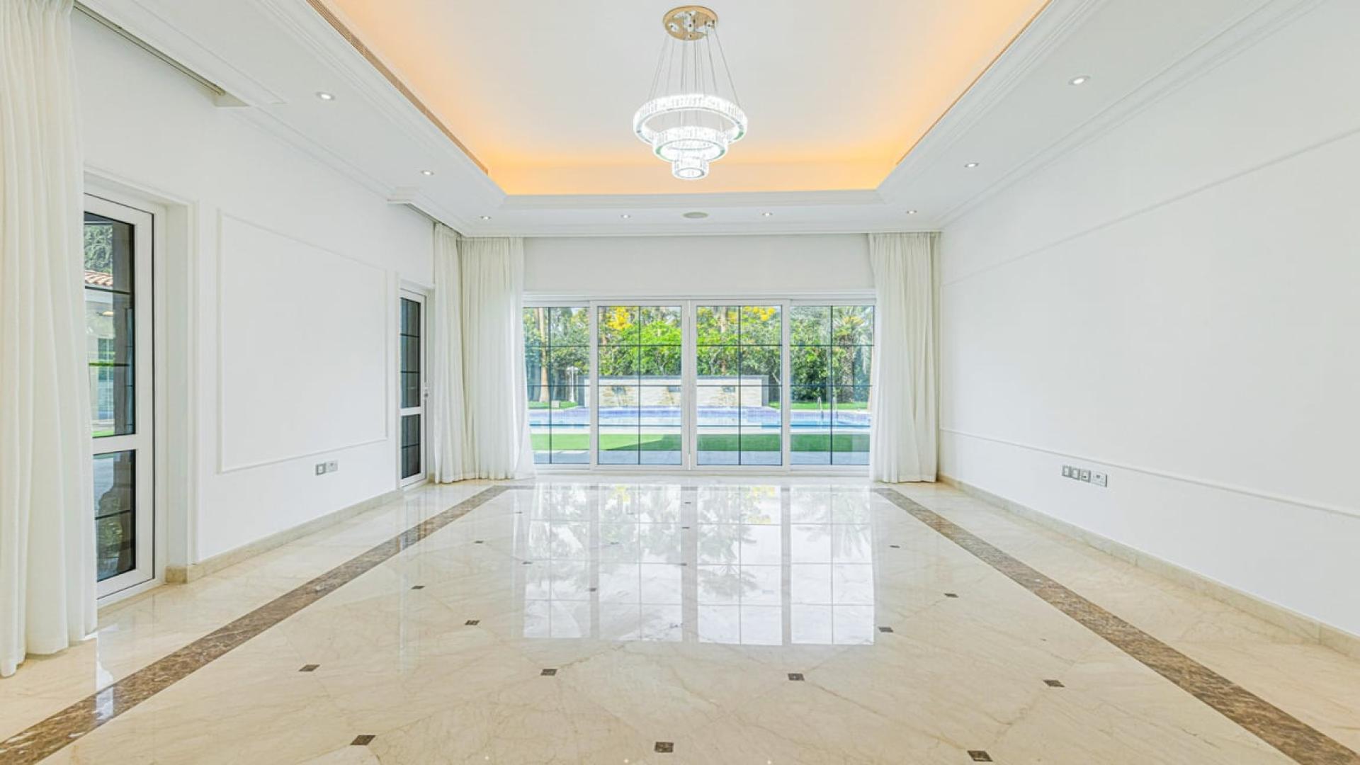 Luxurious villa pool area in Polo Homes, Arabian Ranches, surrounded by lush greenery