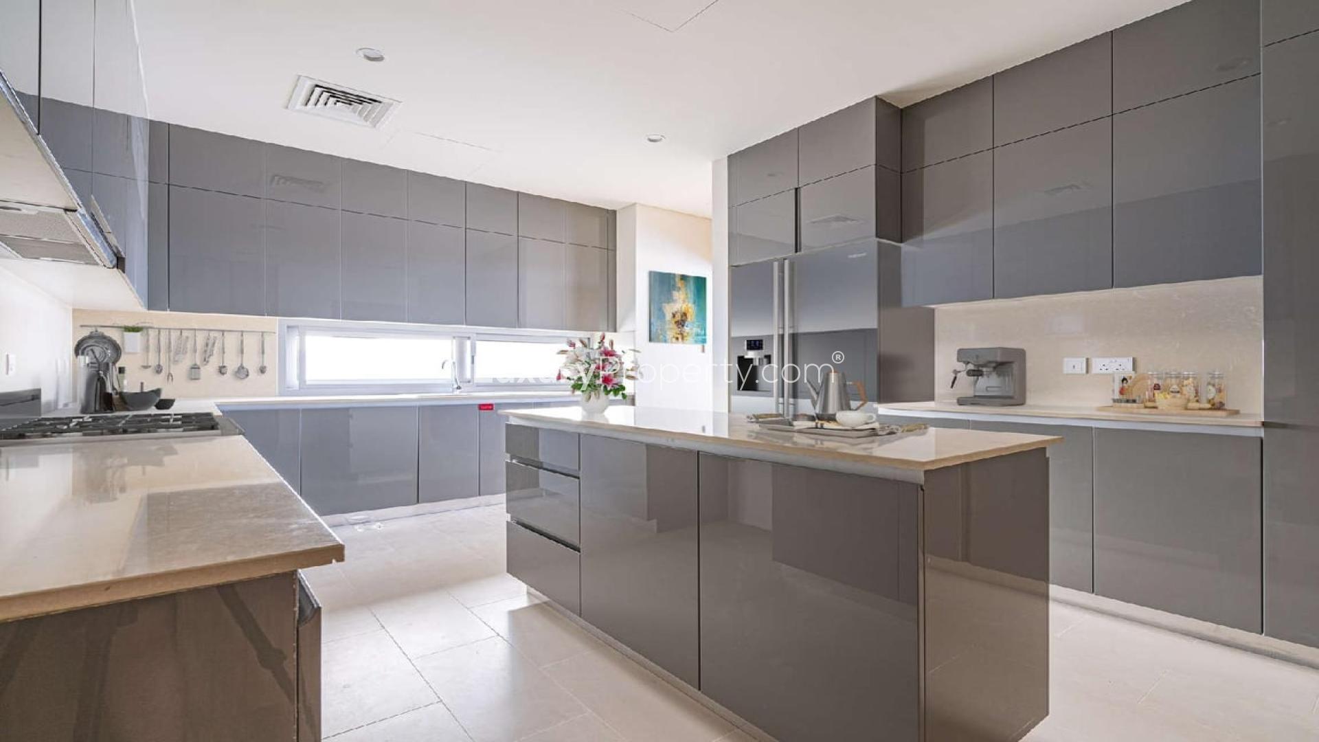 Luxurious open-plan living area in Dubai Hills Estate villa, featuring modern decor and kitchen