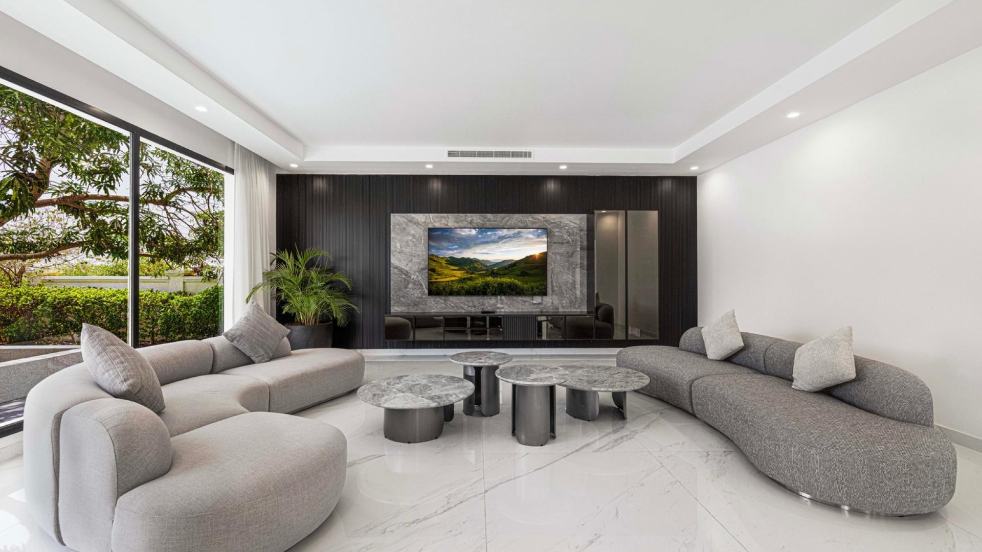 Luxurious living room in 7-bedroom villa, Palm Jumeirah waterfront, modern decor, spacious design