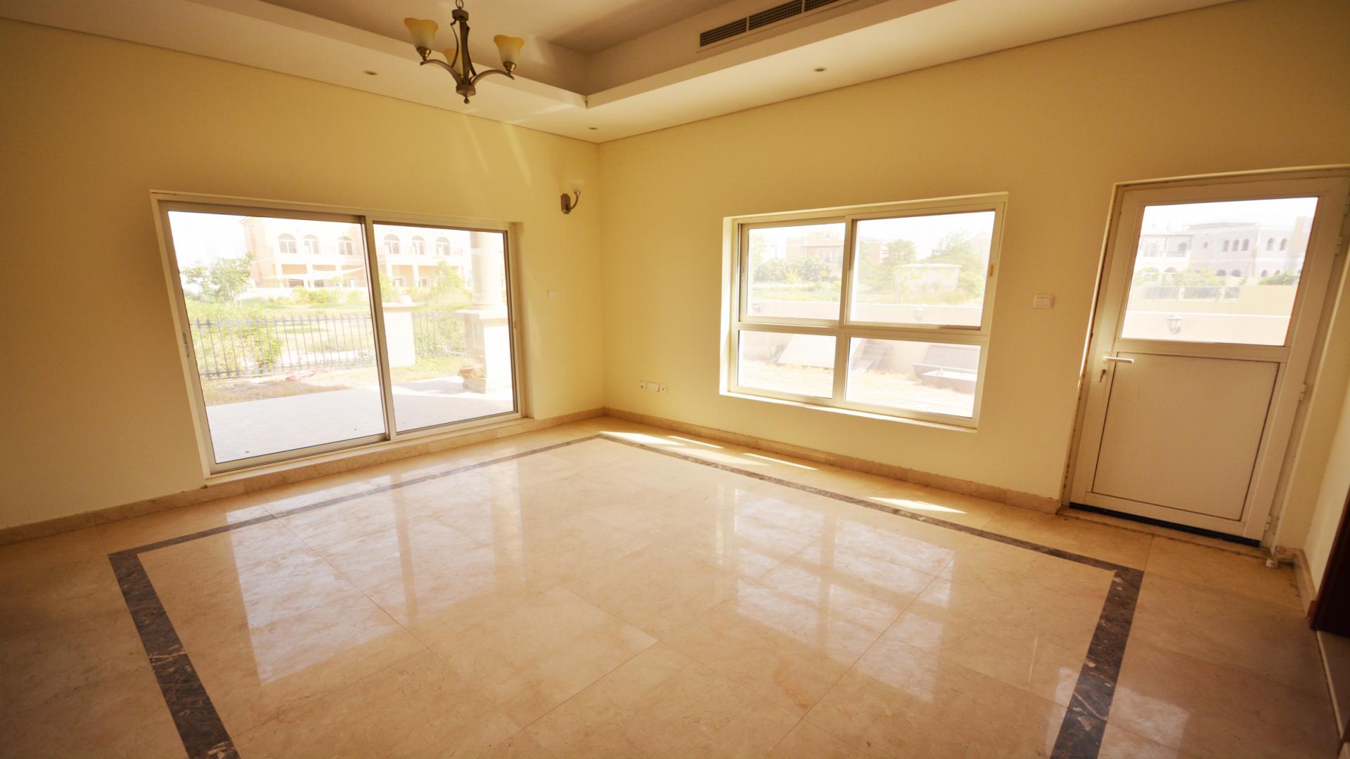 Spacious living room in custom-built villa, marble floors, elegant chandelier, stone fireplace