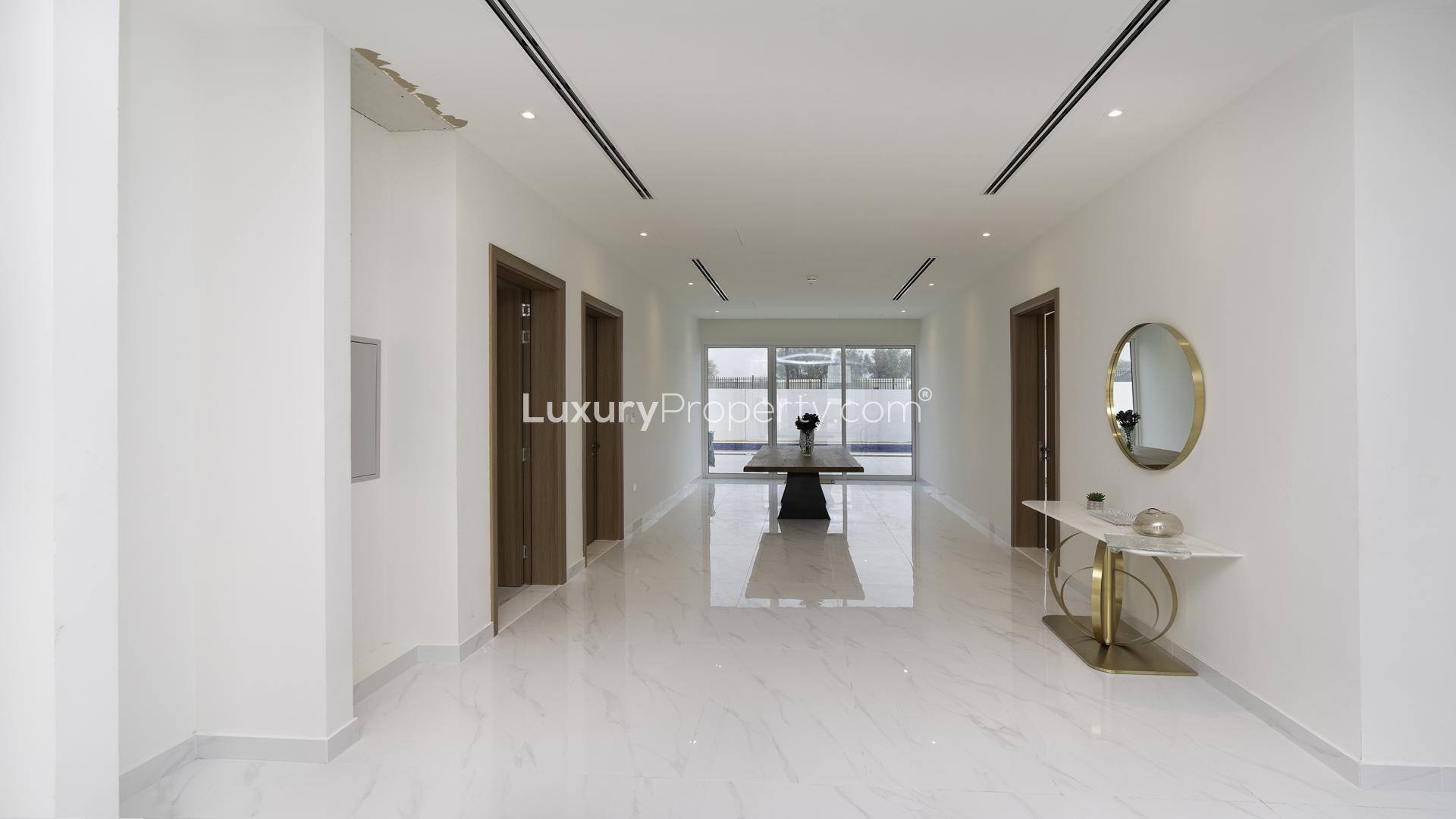 Luxurious living room in Dubai Hills Estate villa with elegant sofas and chandelier