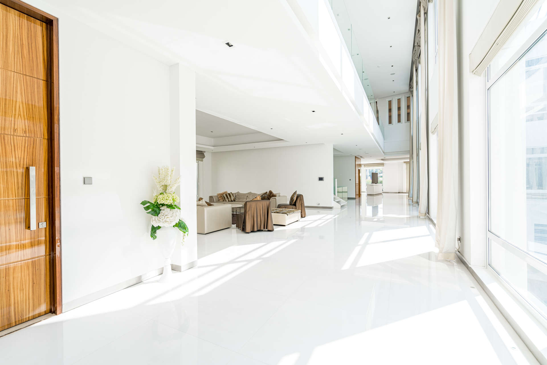 Alt text: "Scenic view of lush greenery and skyline from Emirates Hills villa, Dubai.",Luxurious open-plan living area in 7-bedroom villa, Emirates Hills, Dubai