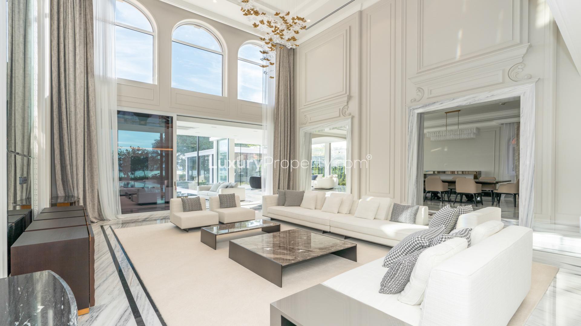 "Luxurious XXII Carat villa with pool, Palm Jumeirah, lush garden view, for sale.",Luxurious living room in XXII Carat villa, Palm Jumeirah, with elegant furnishings and decor