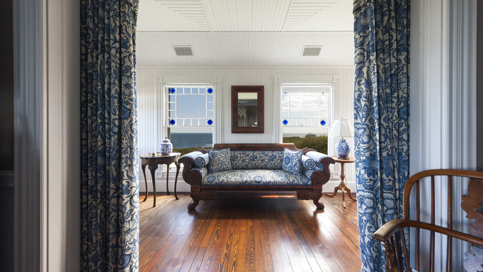 Luxury villa living room with red sofa, bookshelves, and art in Montauk Moorlands