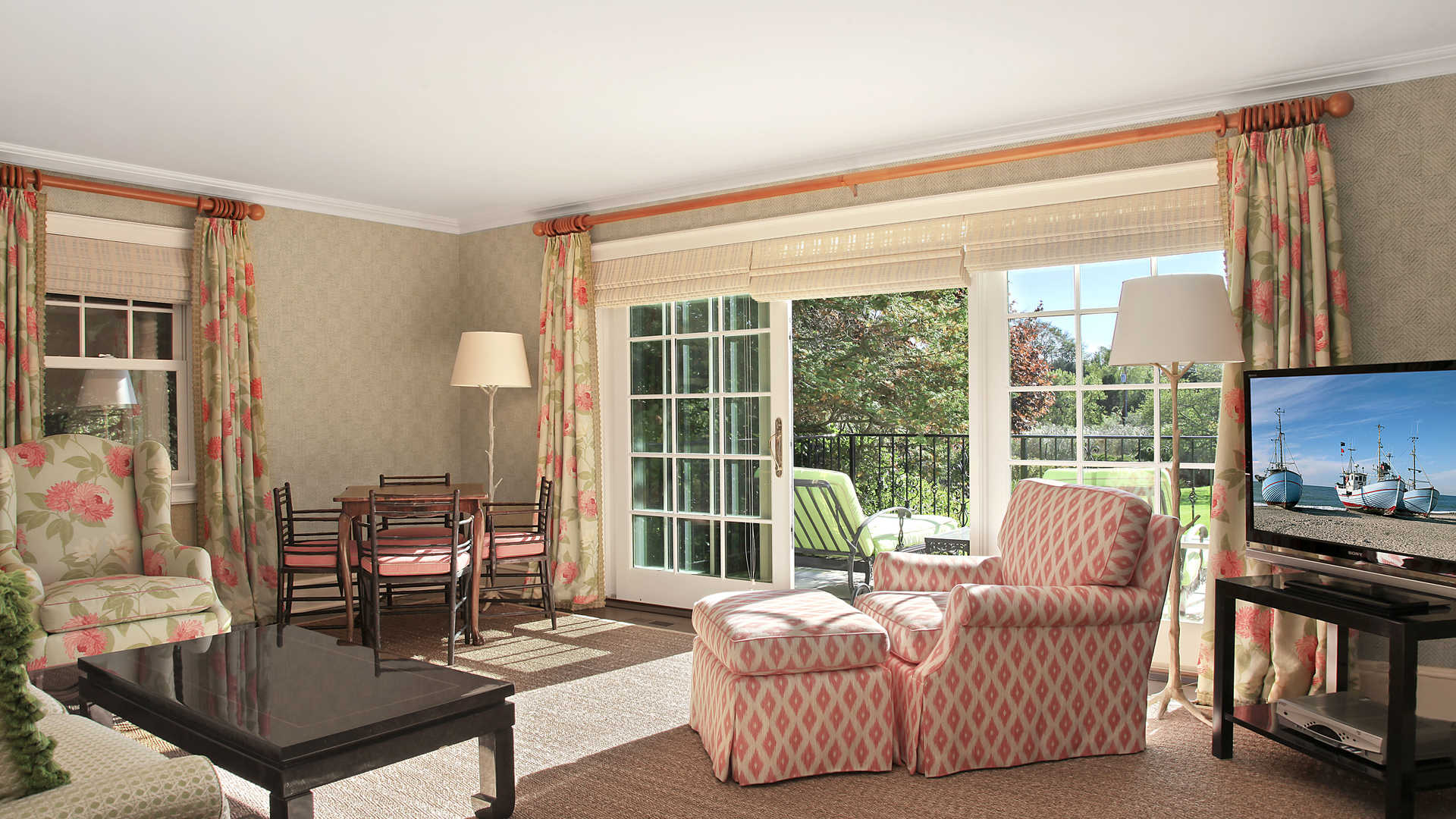 Luxurious villa patio with elegant seating, overlooking pool and lush garden in Southampton