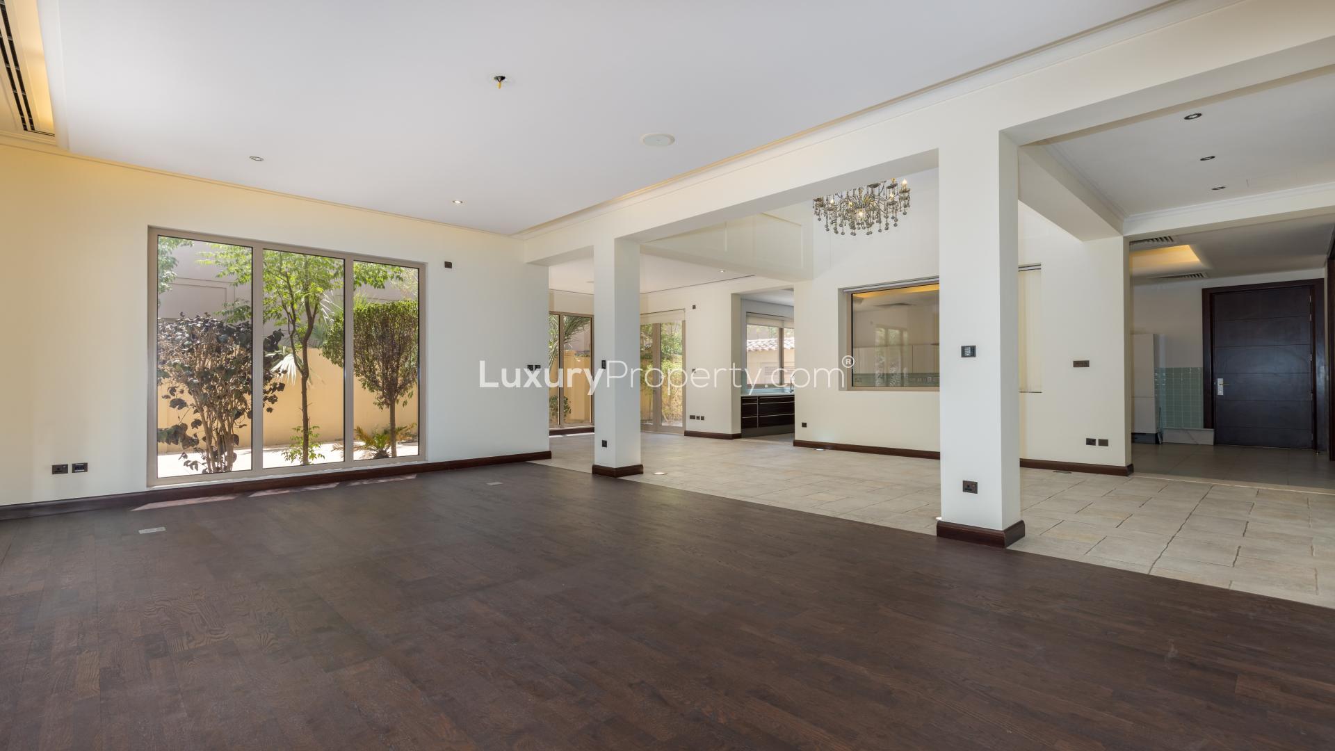 Spacious living room with elegant wallpaper in Al Barari villa for rent