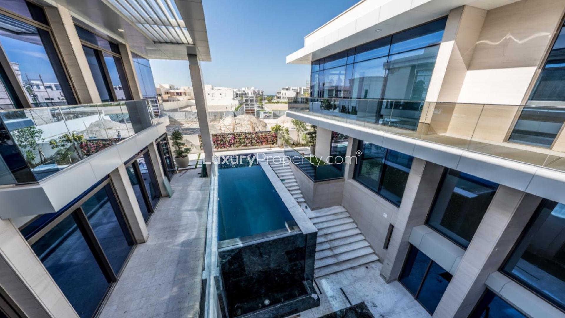 "Pearl Jumeirah villa exterior with modern pool and glass balconies, spacious design.","Elegant Pearl Jumeirah villa interior with modern lighting and high ceilings, LP44214.",Modern interior of Pearl Jumeirah villa with staircase and large windows for sale