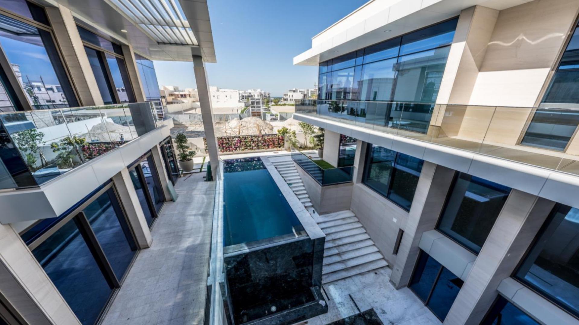 "Pearl Jumeirah villa exterior with modern pool and glass balconies, spacious design.","Elegant Pearl Jumeirah villa interior with modern lighting and high ceilings, LP44214.",Modern interior of Pearl Jumeirah villa with staircase and large windows for sale