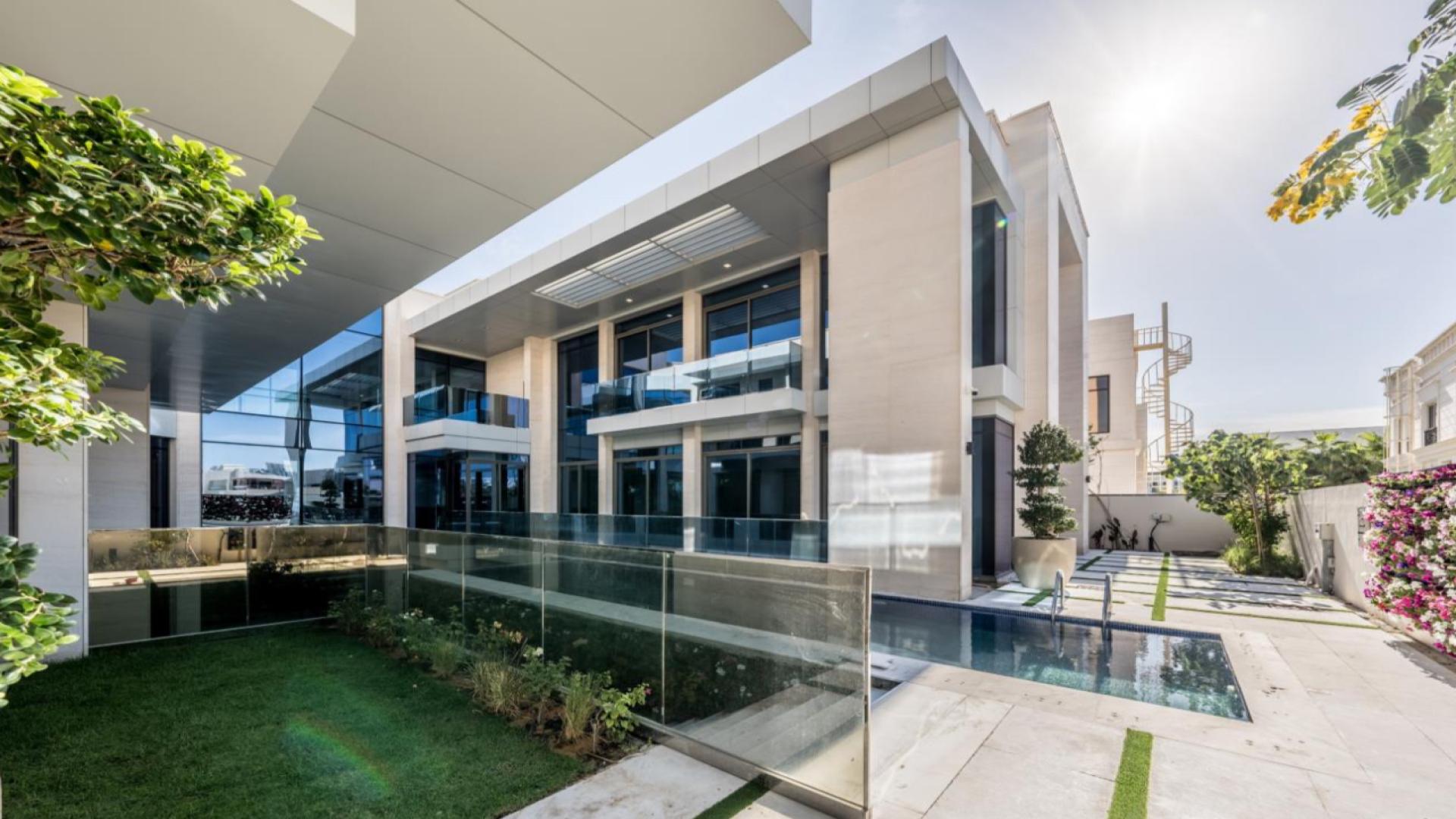 "Modern Pearl Jumeirah villa exterior with glass facade and staircase, LP44214 for sale.",Luxurious Pearl Jumeirah villa exterior with pool, elegant design, and lush garden