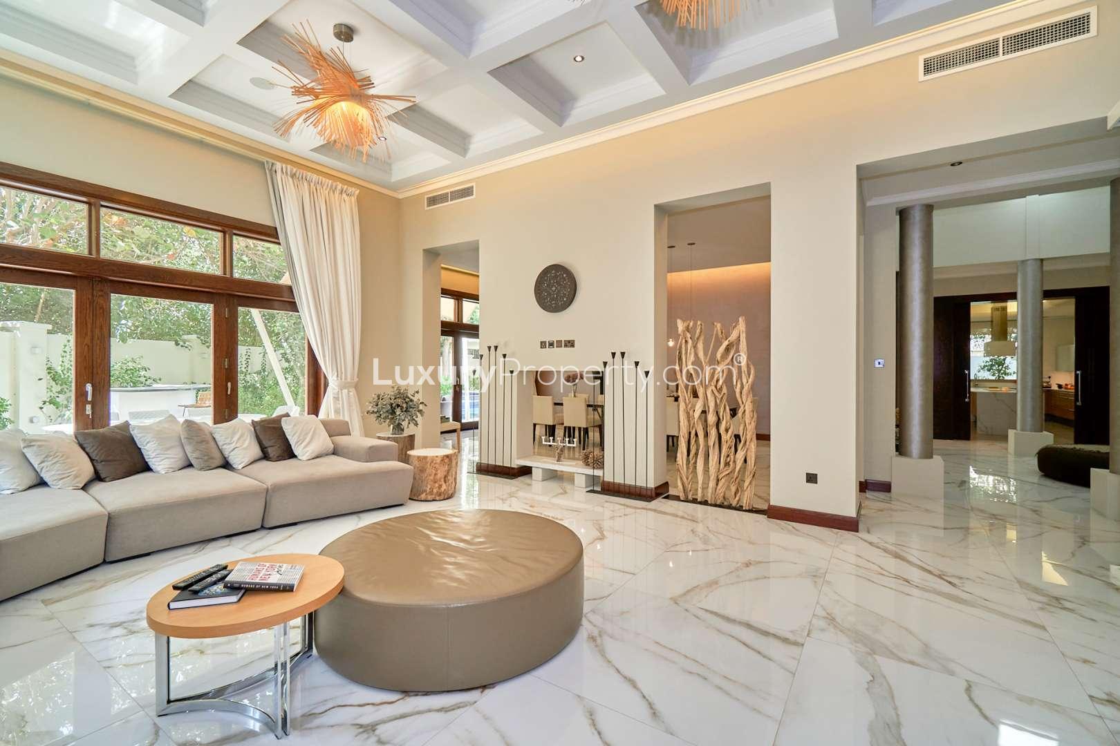 Luxurious poolside view of upgraded villa in Al Barari, Dubai, with shaded seating area