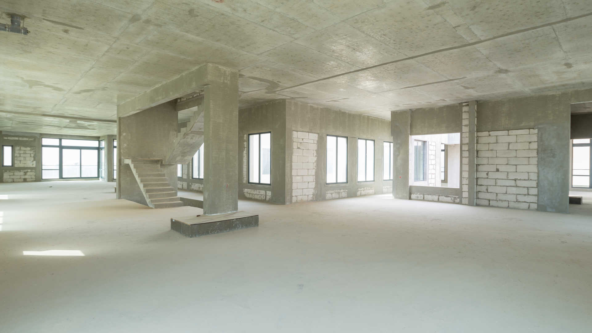 Spacious interior of seven-bedroom villa in Dubai Hills View, featuring large windows and unfinished walls