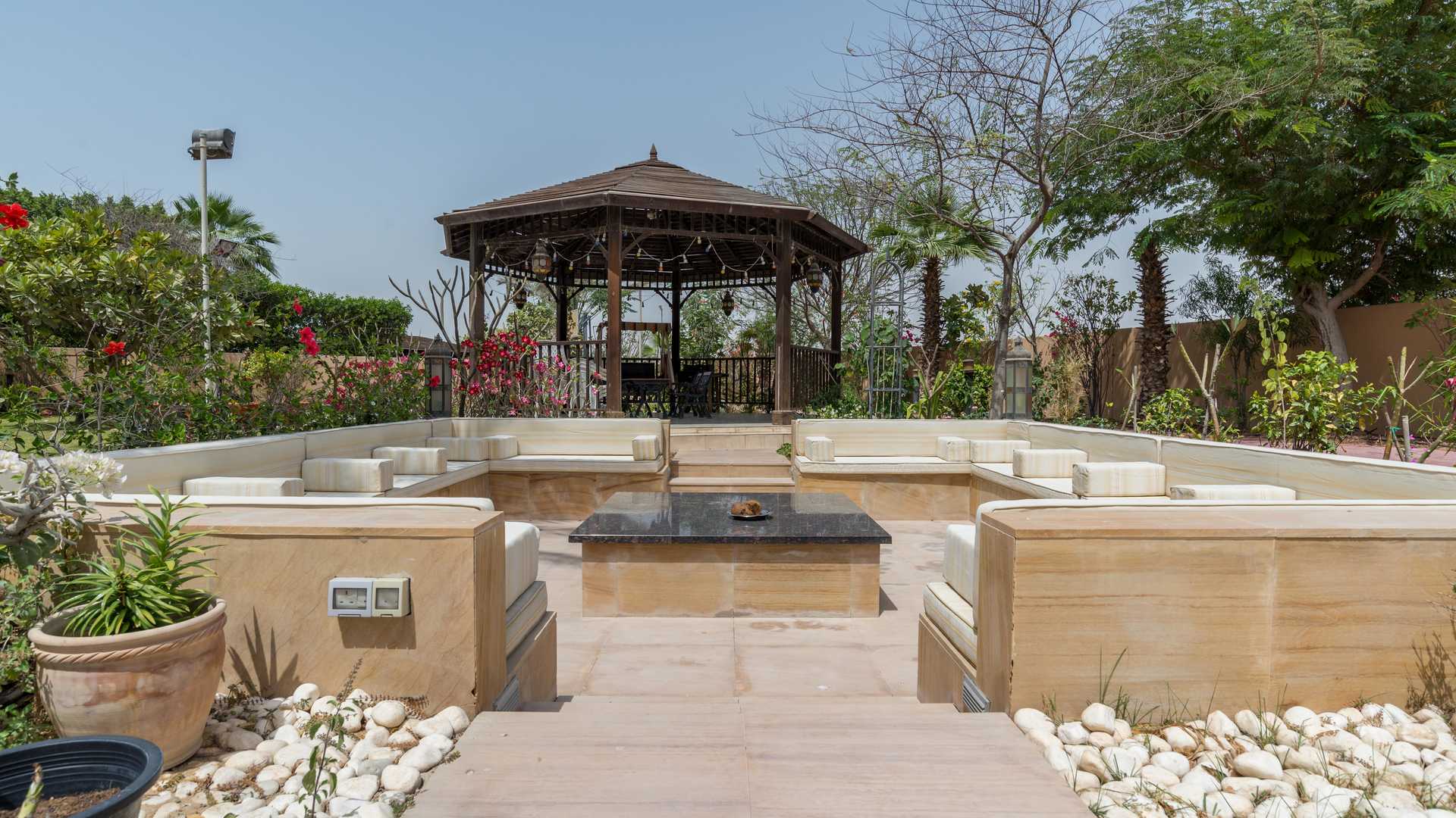 "Spacious garden of 7-bedroom villa in Hattan, Arabian Ranches, Dubai for sale.",Outdoor seating area with gazebo at 7-bedroom villa, Arabian Ranches, Dubai