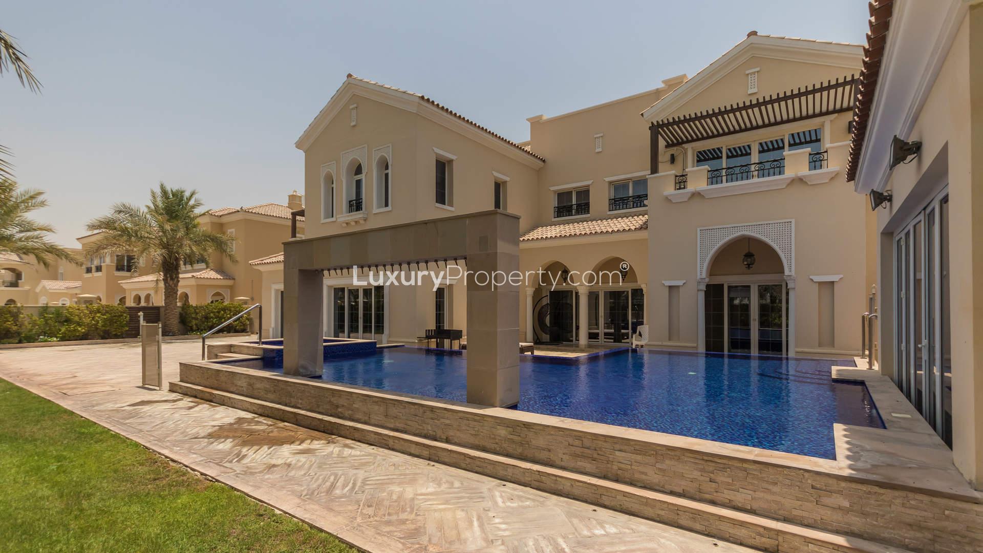 Luxurious villa pool in Polo Homes, Arabian Ranches, surrounded by palm trees