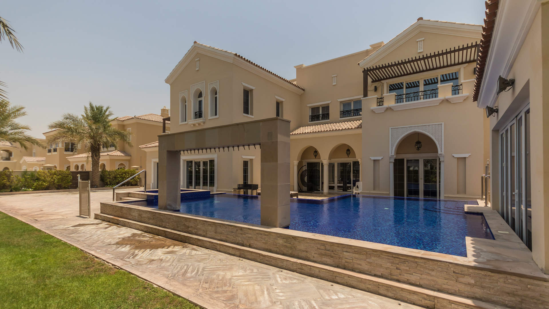 Luxurious villa pool in Polo Homes, Arabian Ranches, surrounded by palm trees