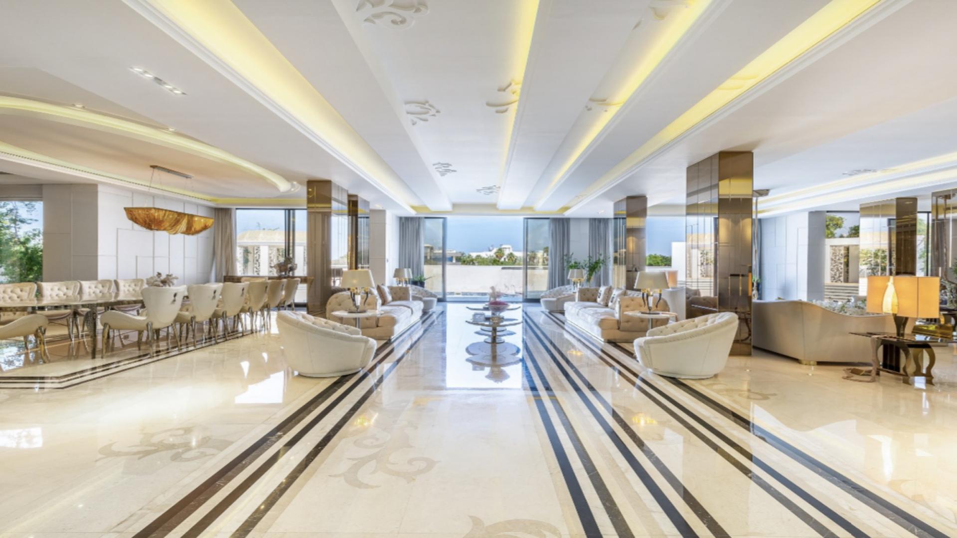 Luxurious 7-bedroom villa exterior in Sector L, Emirates Hills, with palm trees and driveway