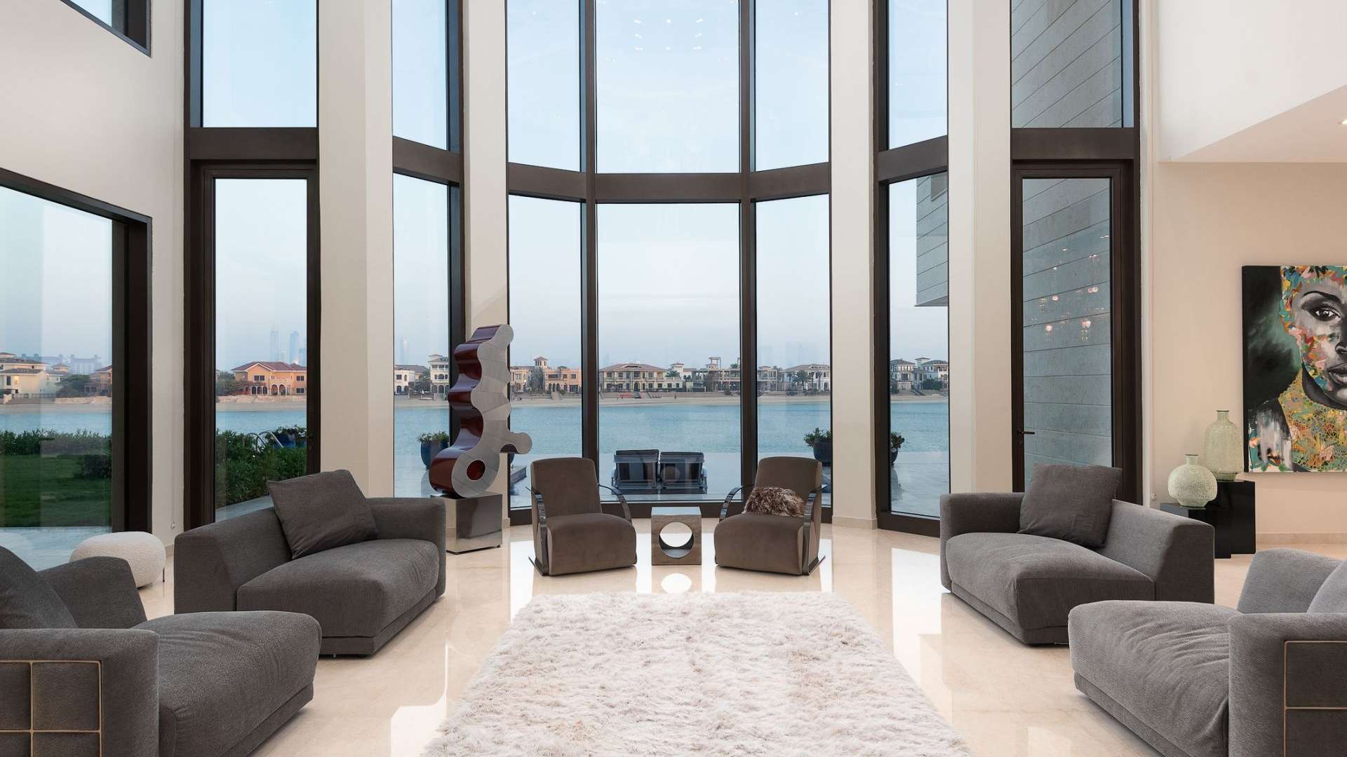 Luxurious living room with floor-to-ceiling windows in Palm Jumeirah villa, overlooking the pool