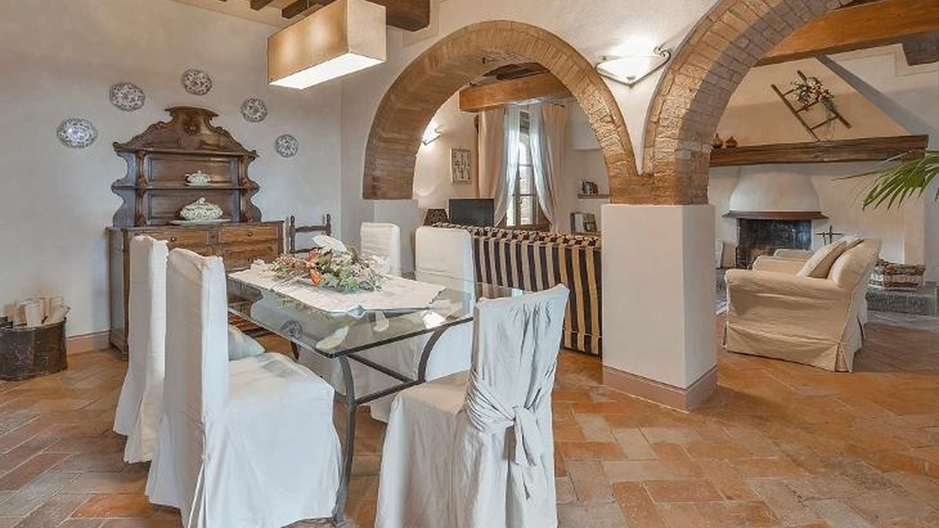 19th-century Villa Quercia living room with rustic arches and wooden beams in Chianni