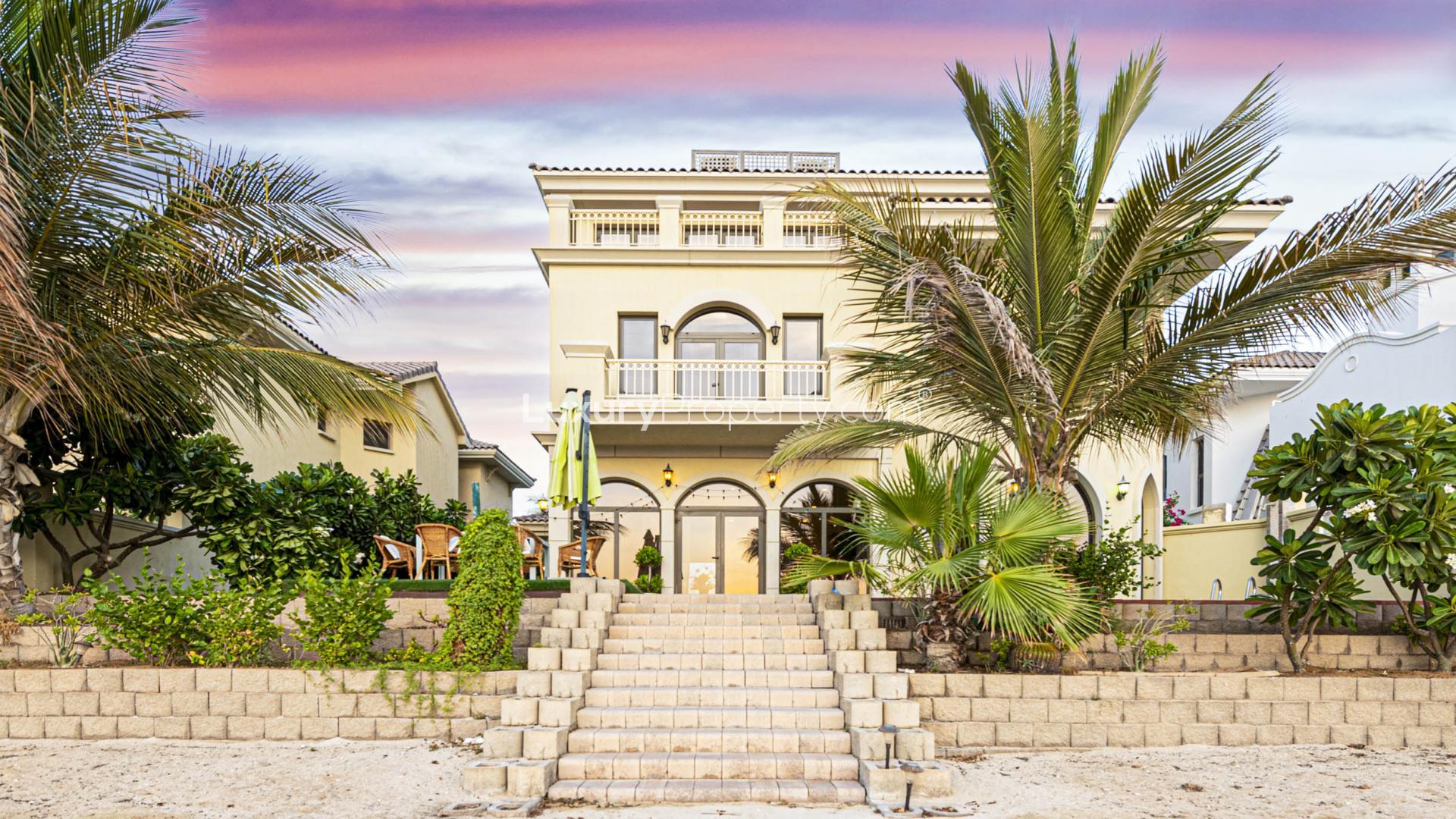 Outdoor dining area with pool and waterfront view at Villa Exotica, Palm Jumeirah