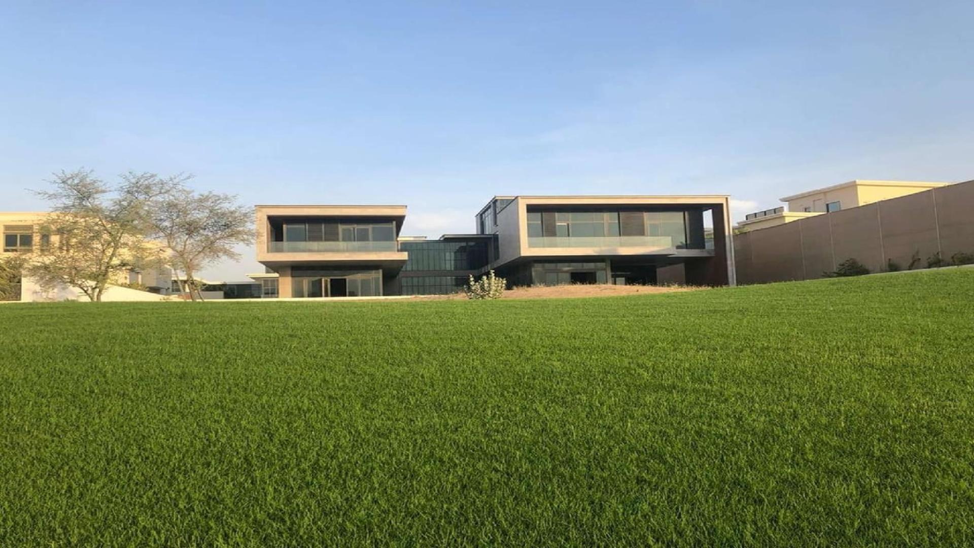 Modern 8-bedroom villa exterior in Dubai Hills Grove, lush green lawn in foreground