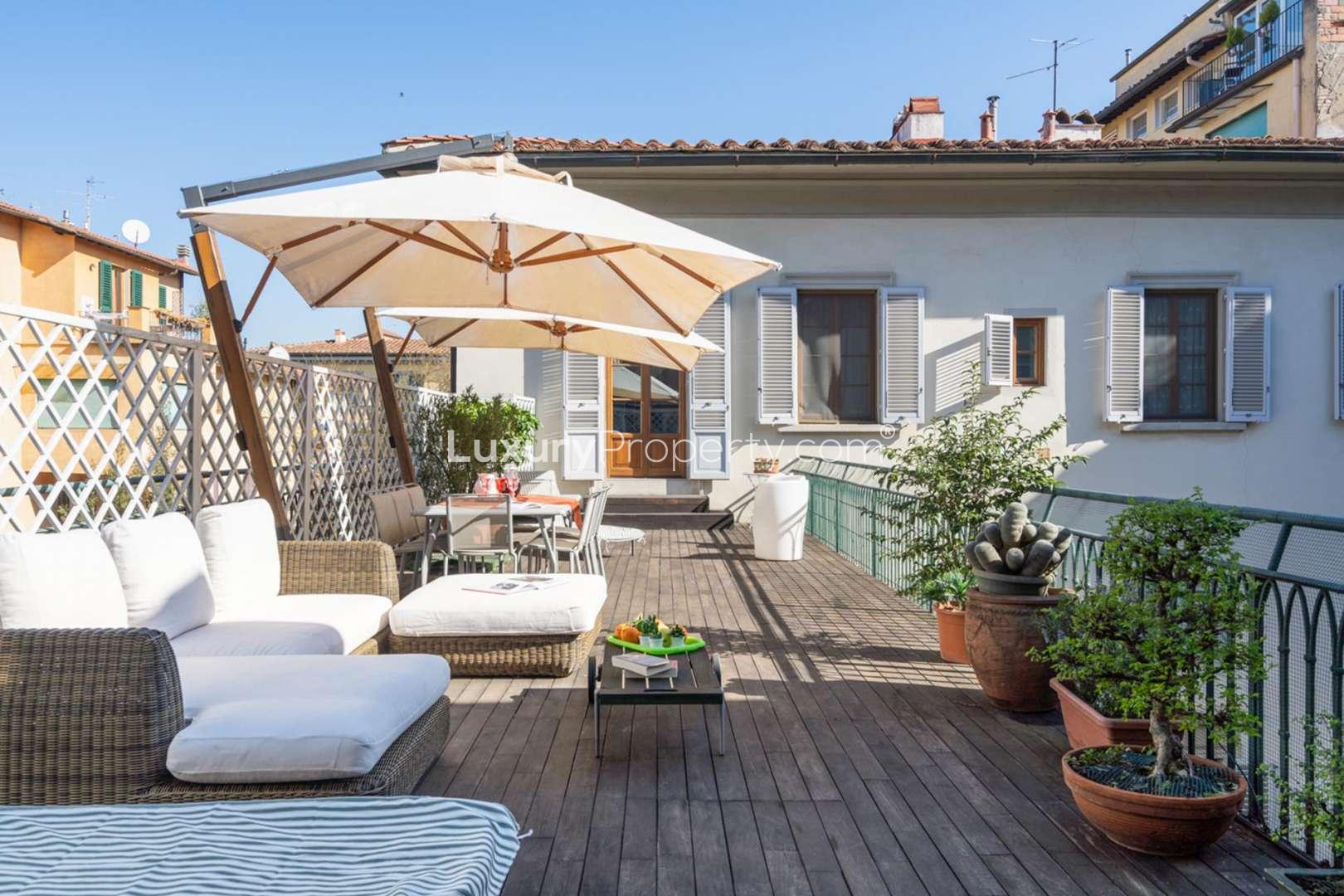 Outdoor hot tub area in deluxe Florence penthouse for sale, featuring lush greenery