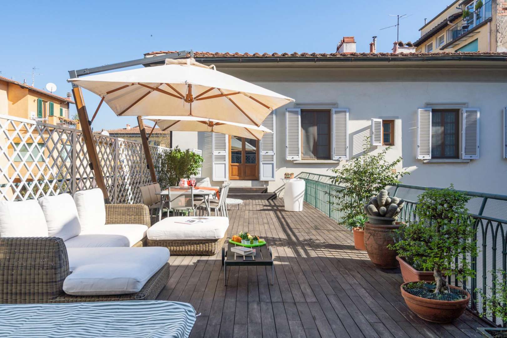 Outdoor hot tub area in deluxe Florence penthouse for sale, featuring lush greenery