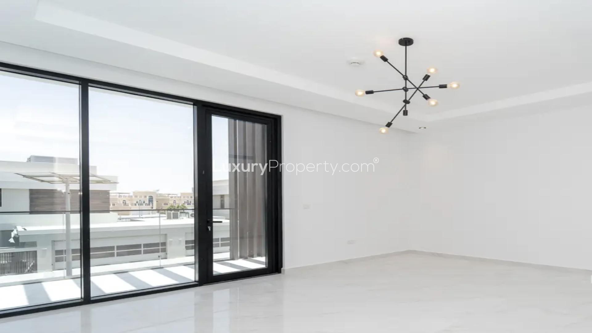 Bright empty room with modern chandelier and large windows in Jumeirah Islands villa