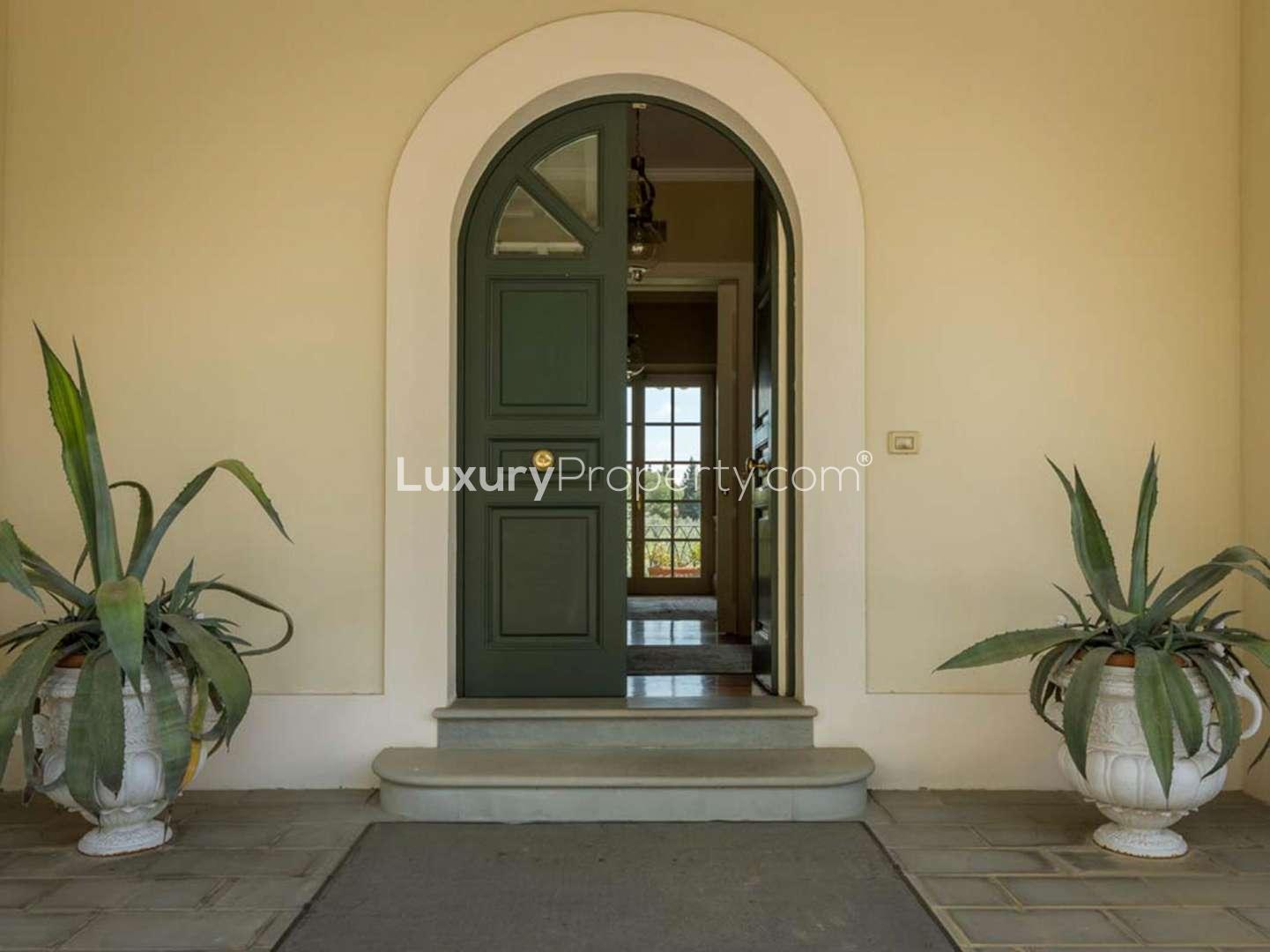 Front entrance of eight-bed villa in Villa Fiorenzia, Florence, surrounded by lush greenery