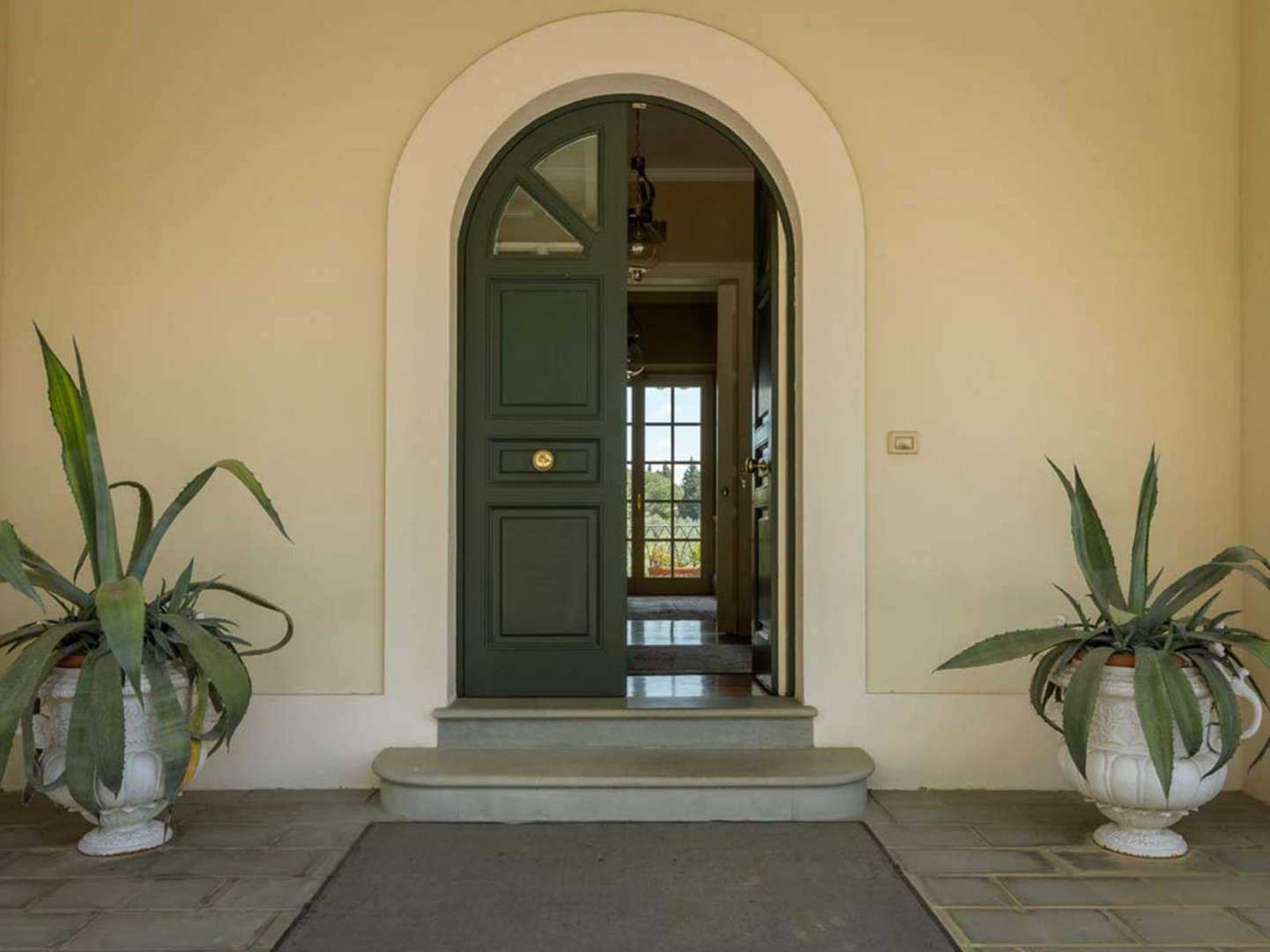 Front entrance of eight-bed villa in Villa Fiorenzia, Florence, surrounded by lush greenery