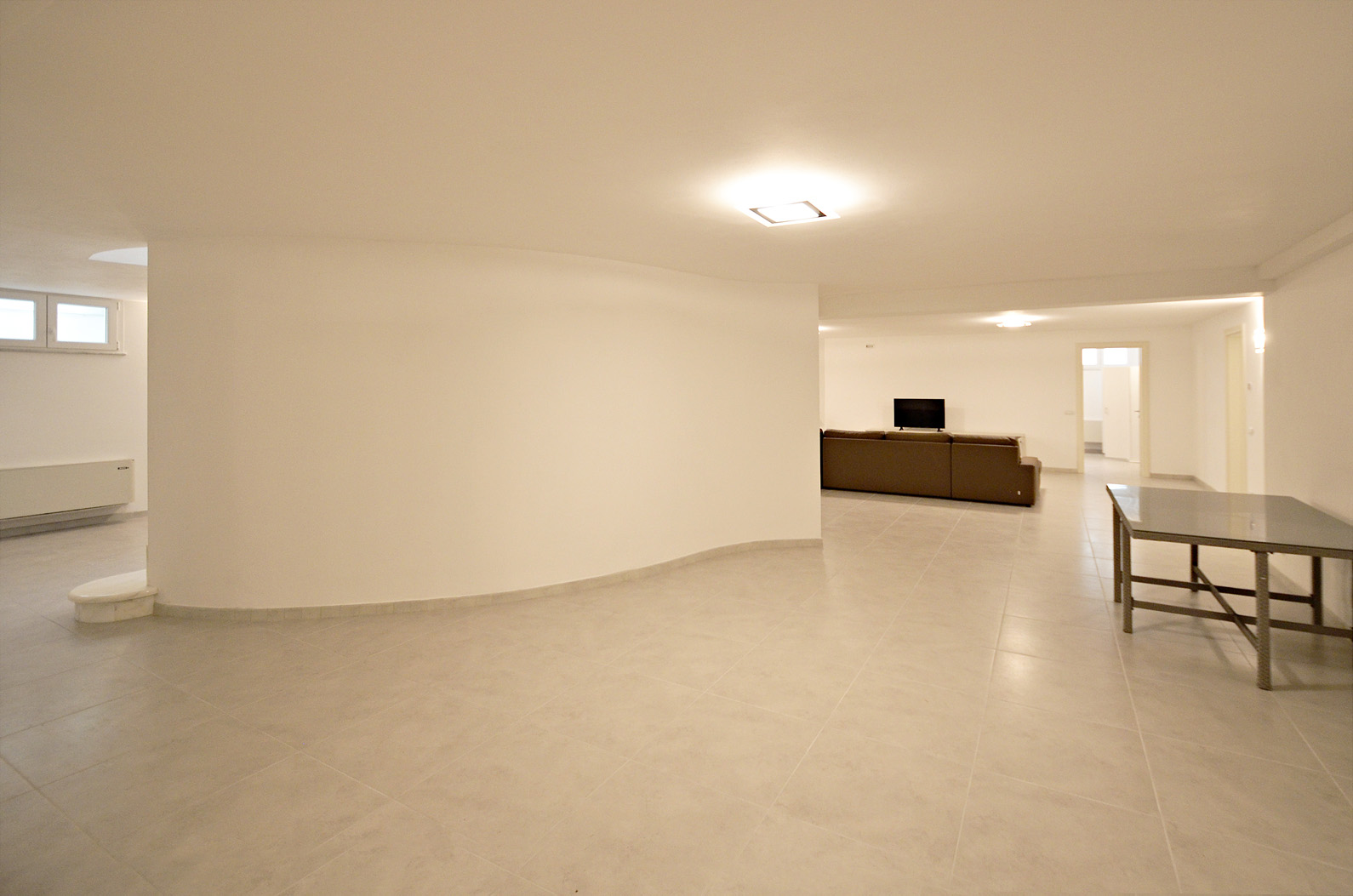 Modern open-plan interior with elegant staircase in Villa Giotto, Lucca, Italy