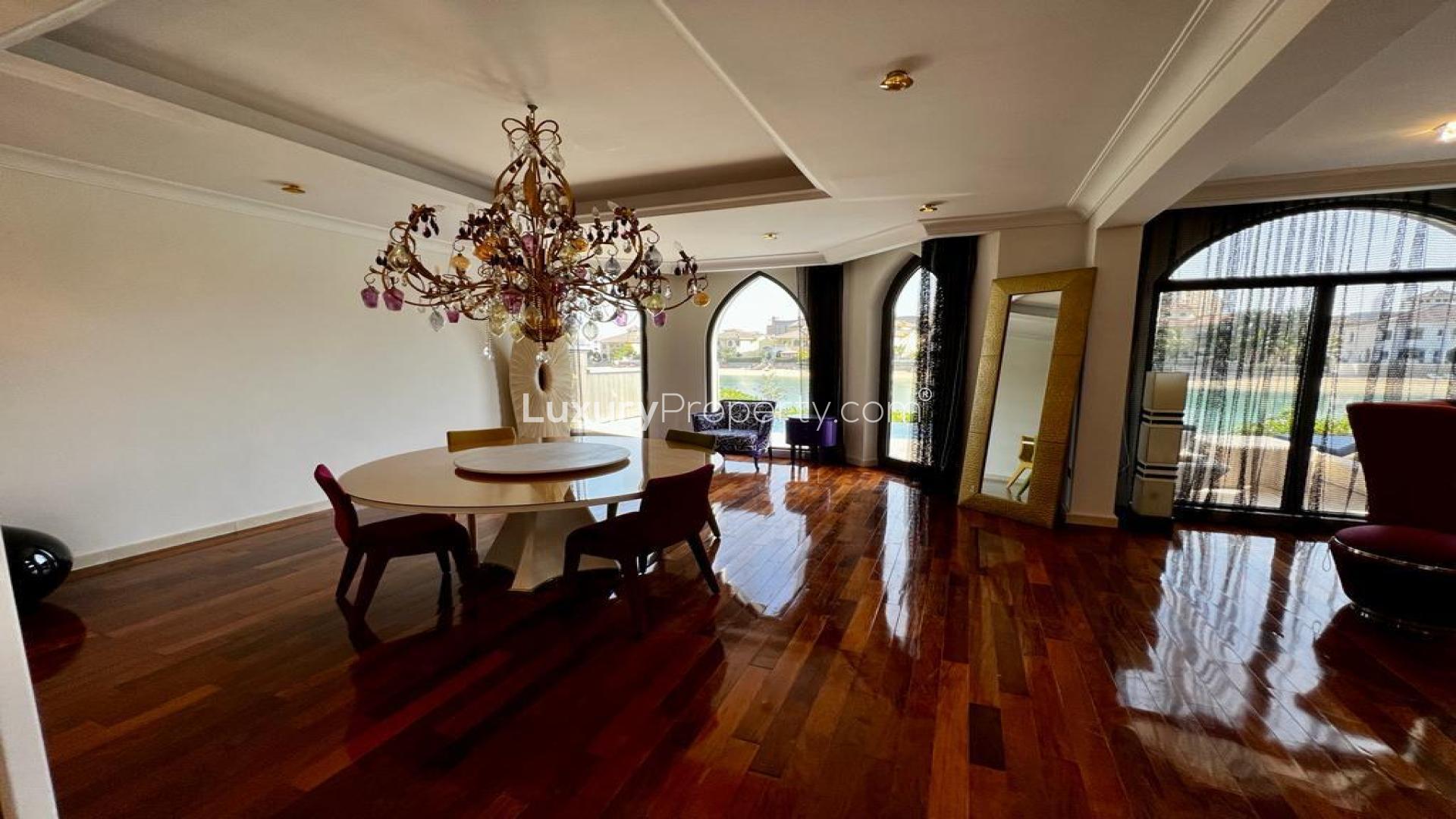 Luxurious villa hallway with red accent wall, ornate decor, and hardwood flooring