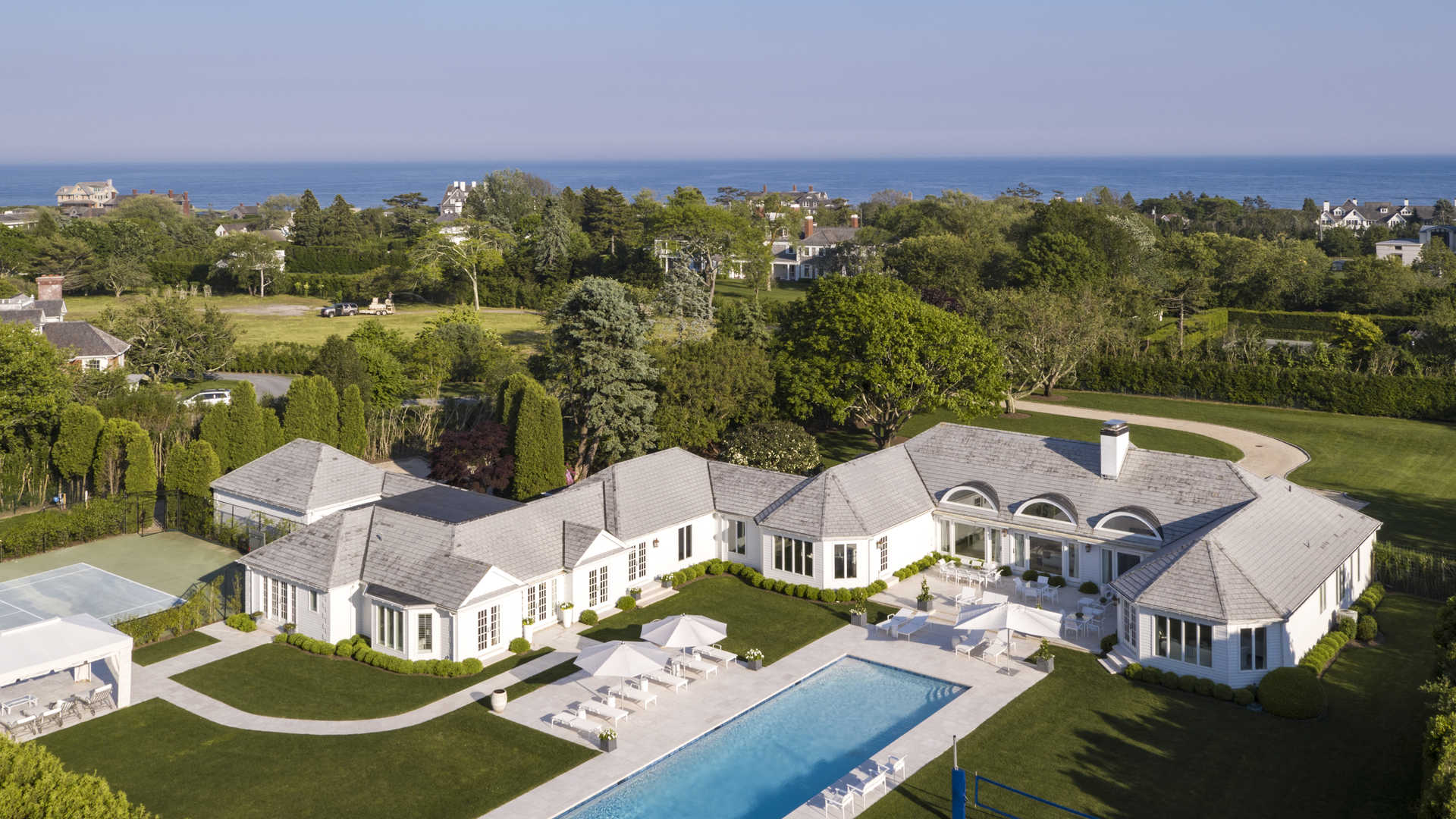 Luxurious villa with poolside patio and sun loungers in Southampton's exclusive Hamptons community