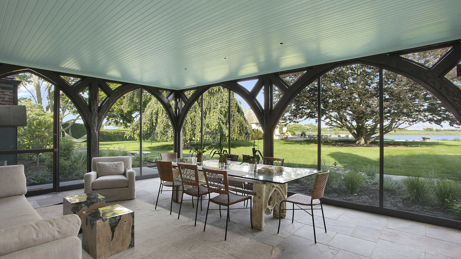 Luxurious bedroom in Hamptons villa with elegant decor, large windows, and cozy seating area