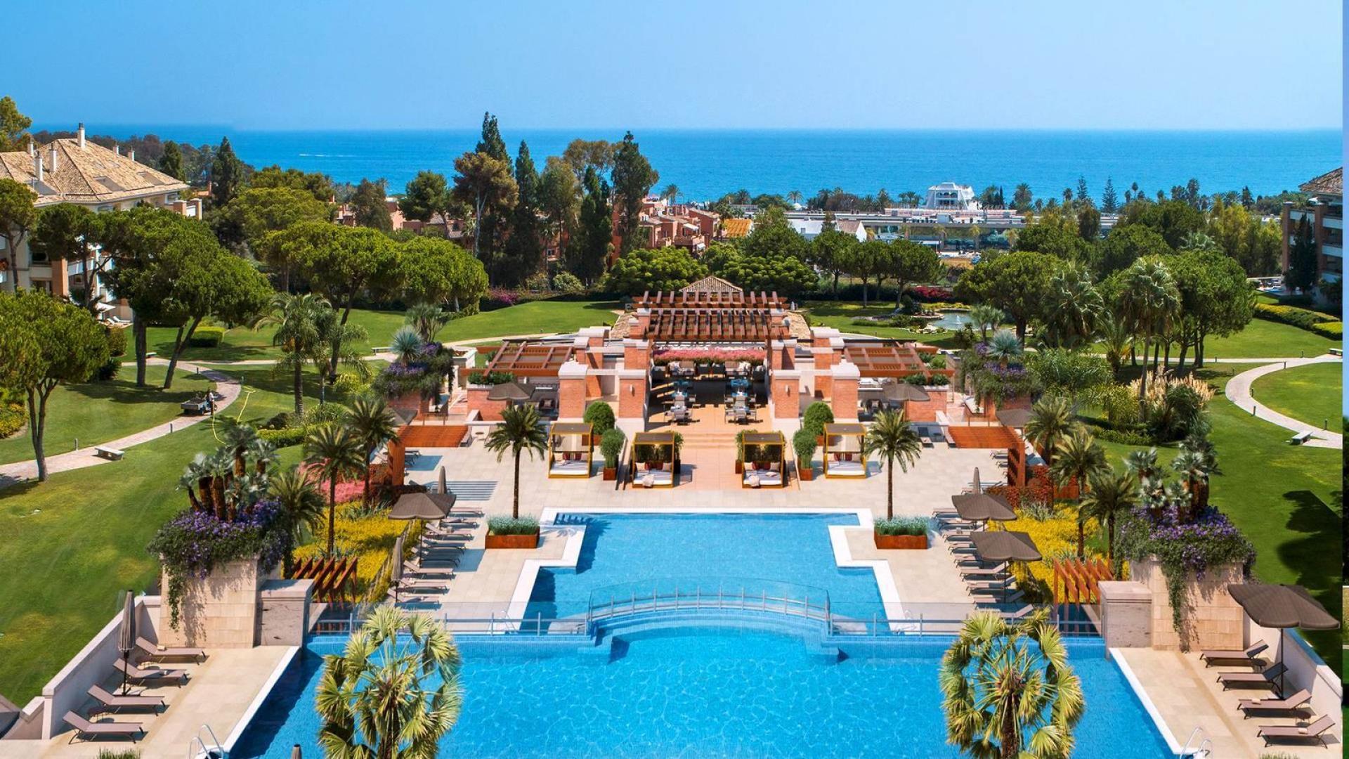 Luxury Marbella penthouse view with pool, gardens, and scenic landscape in Málaga community