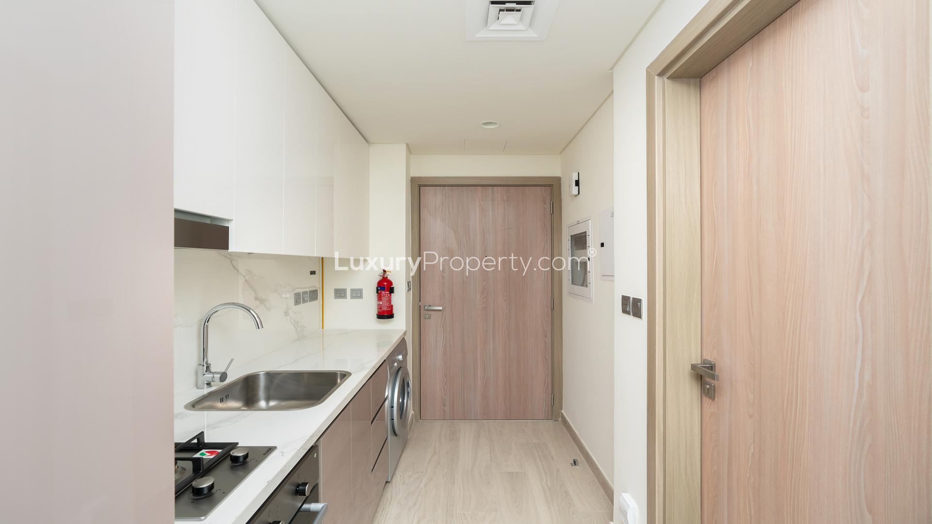 Modern kitchen in elegant studio apartment at Azizi Riviera, Meydan One, for sale