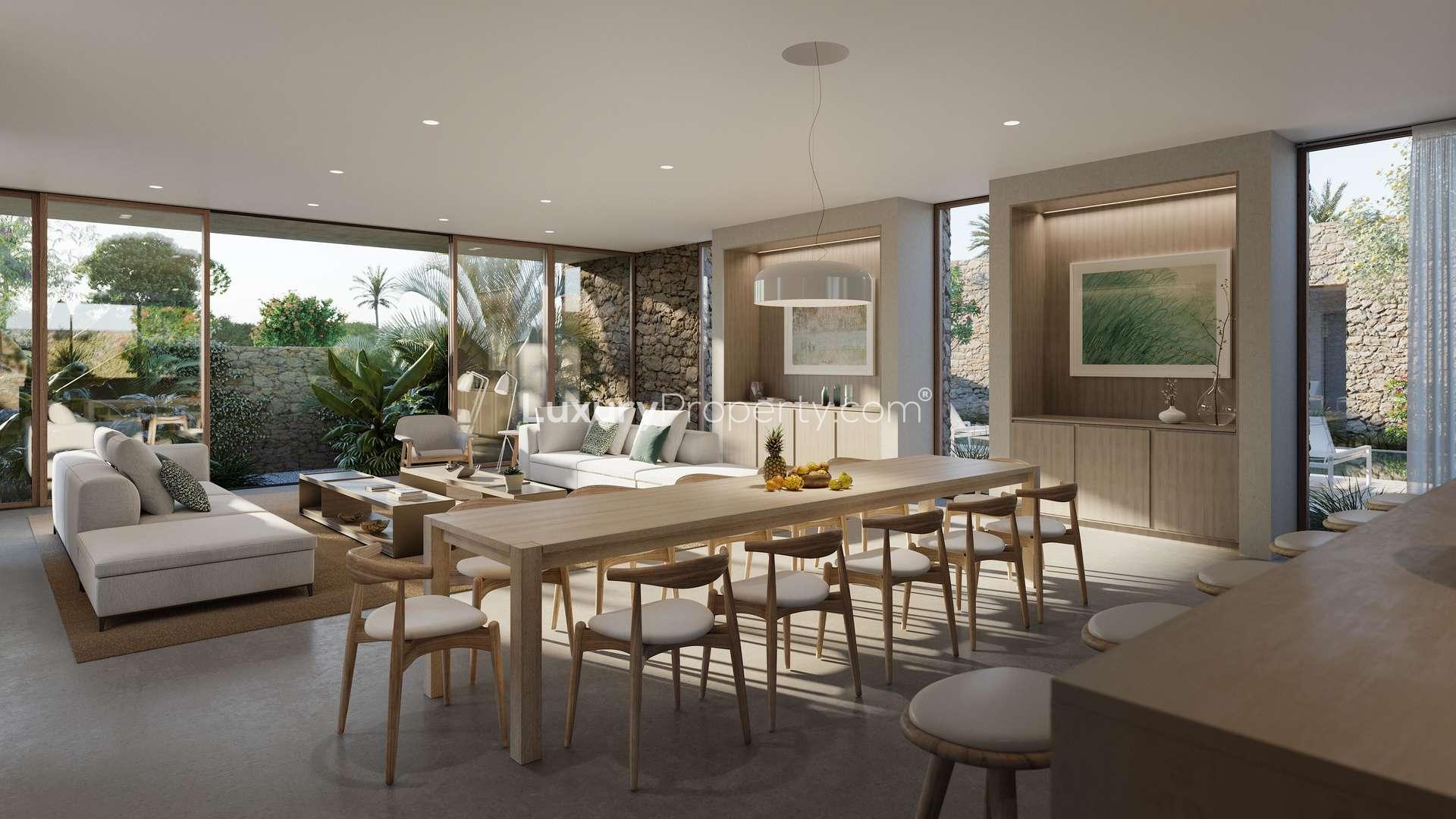 Open-plan living area in Ghusoon Villa, featuring modern kitchen and garden view