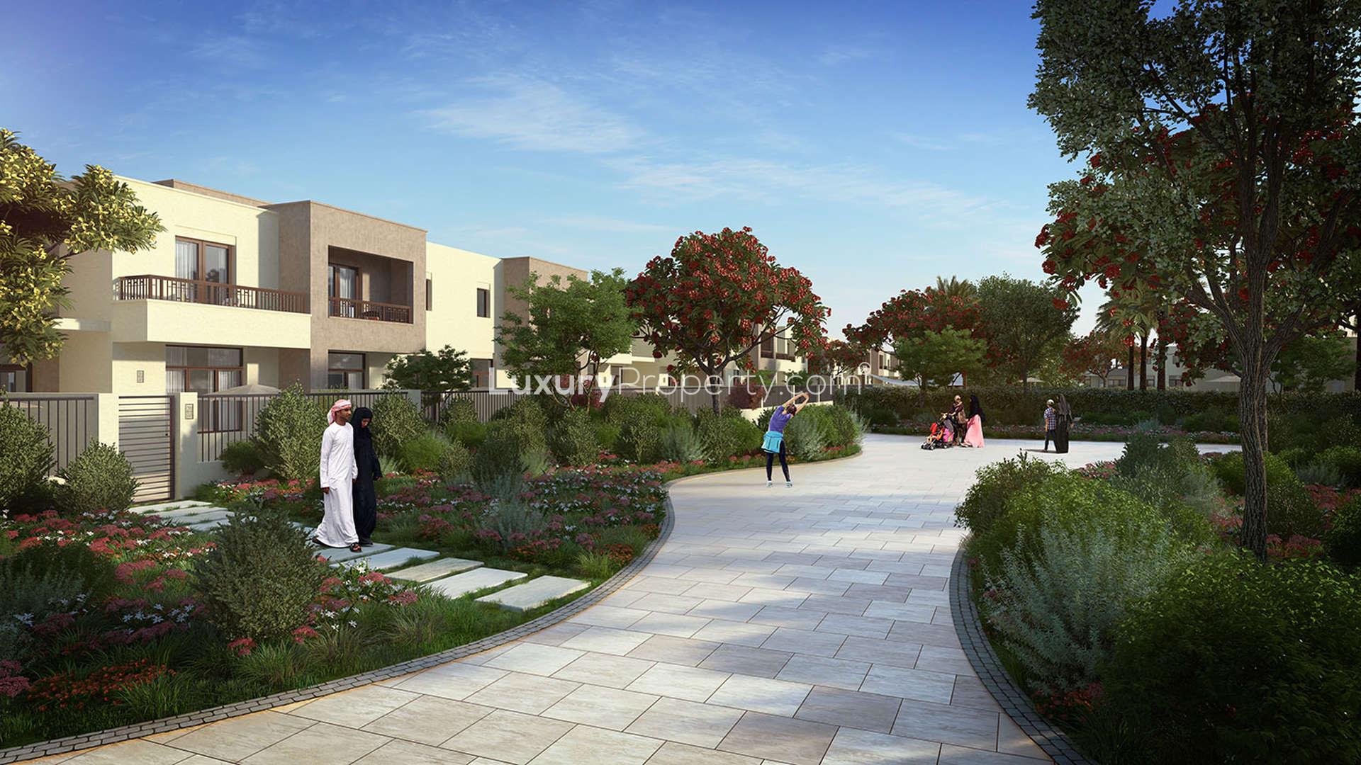 Street view of luxury townhouses with lush greenery in Noor Townhouses, Dubai Town Square