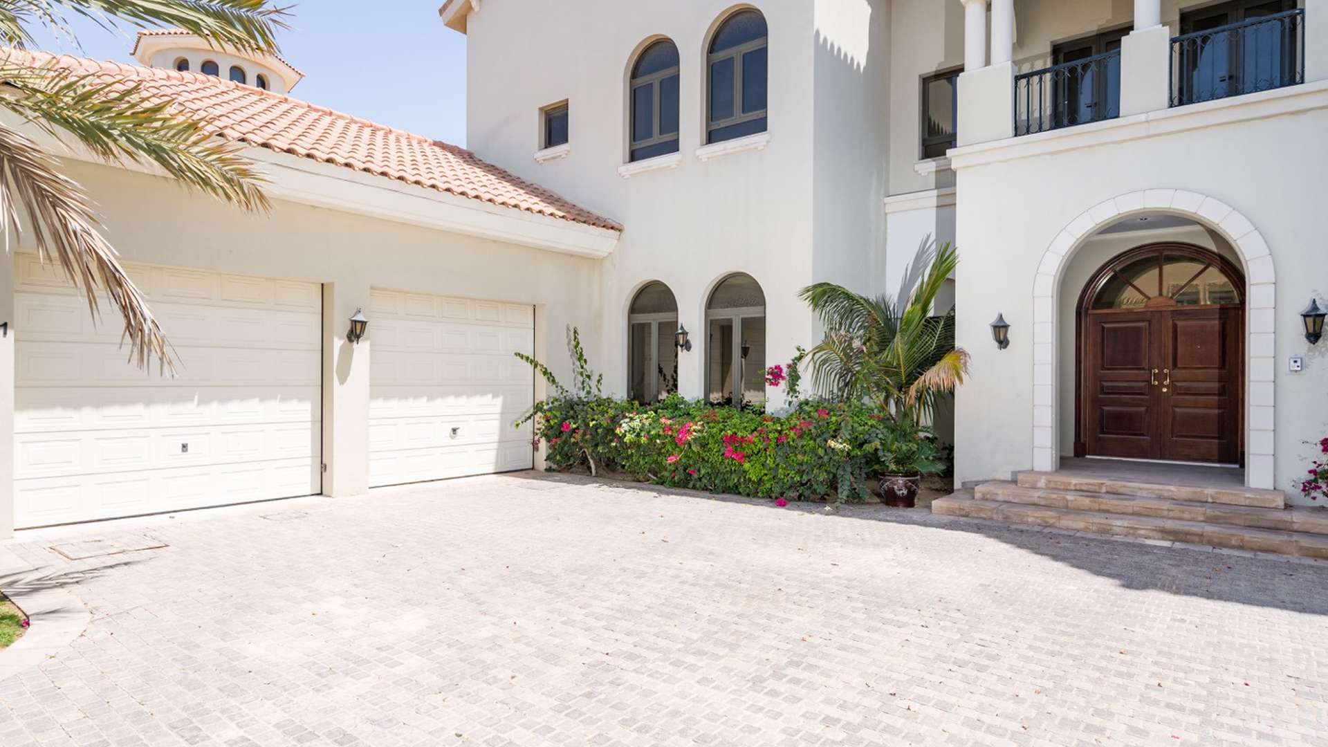 Front entrance of luxurious beachfront villa in Palm Jumeirah with double garage and garden