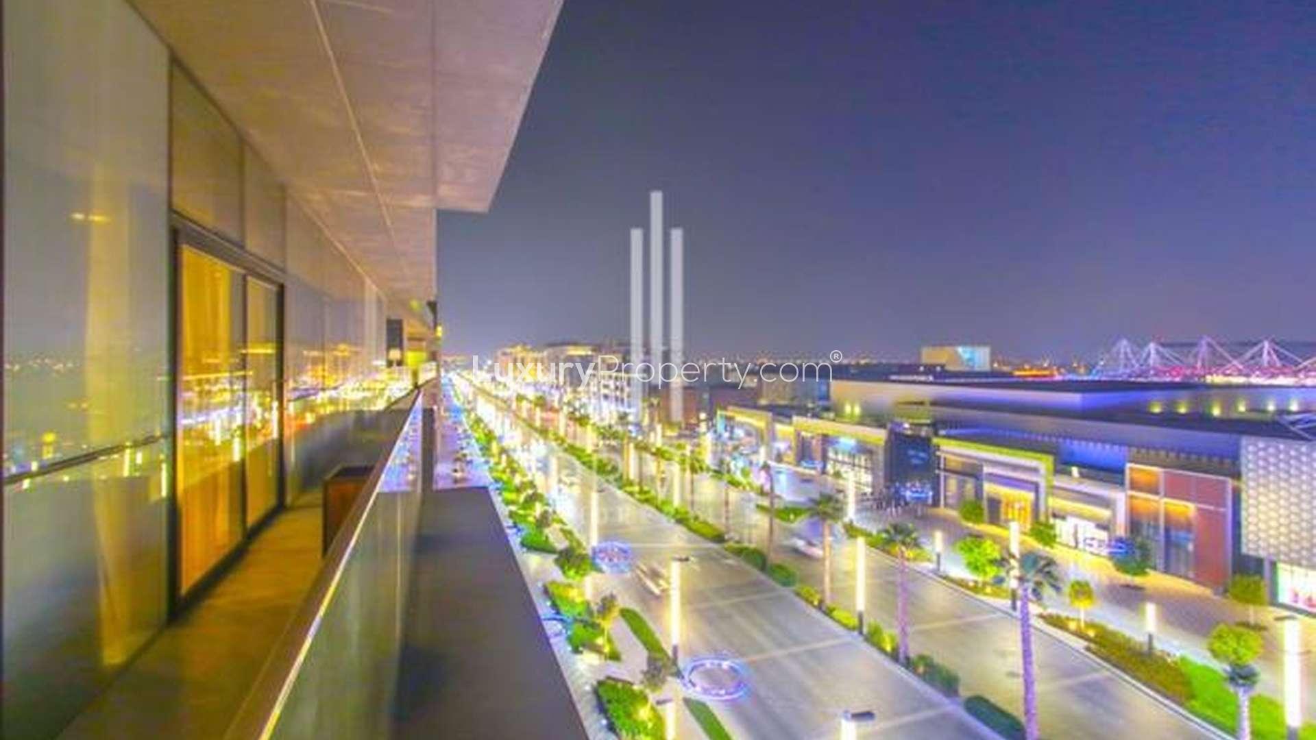 City Walk penthouse balcony view at night, overlooking illuminated street and vibrant community