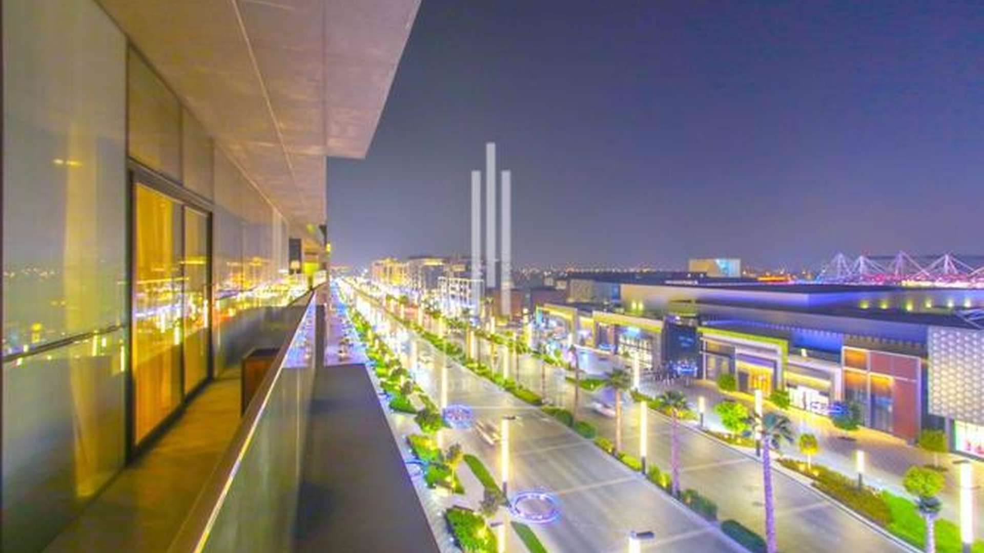 City Walk penthouse balcony view at night, overlooking illuminated street and vibrant community