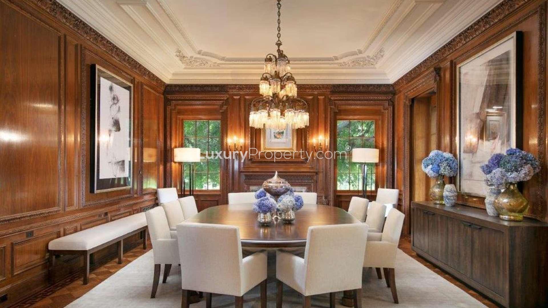Luxurious dining room in Holmby Hills villa, featuring elegant chandelier and wood paneling