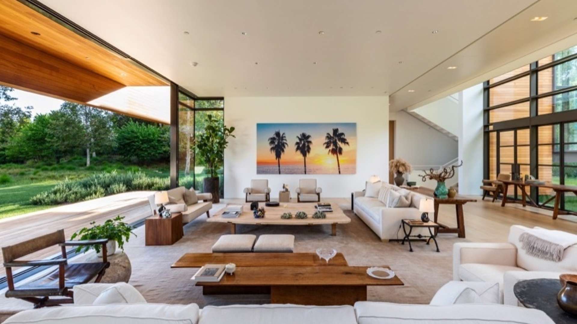 Driveway lined with lush greenery at Beverly Hills villa, clear blue sky above
