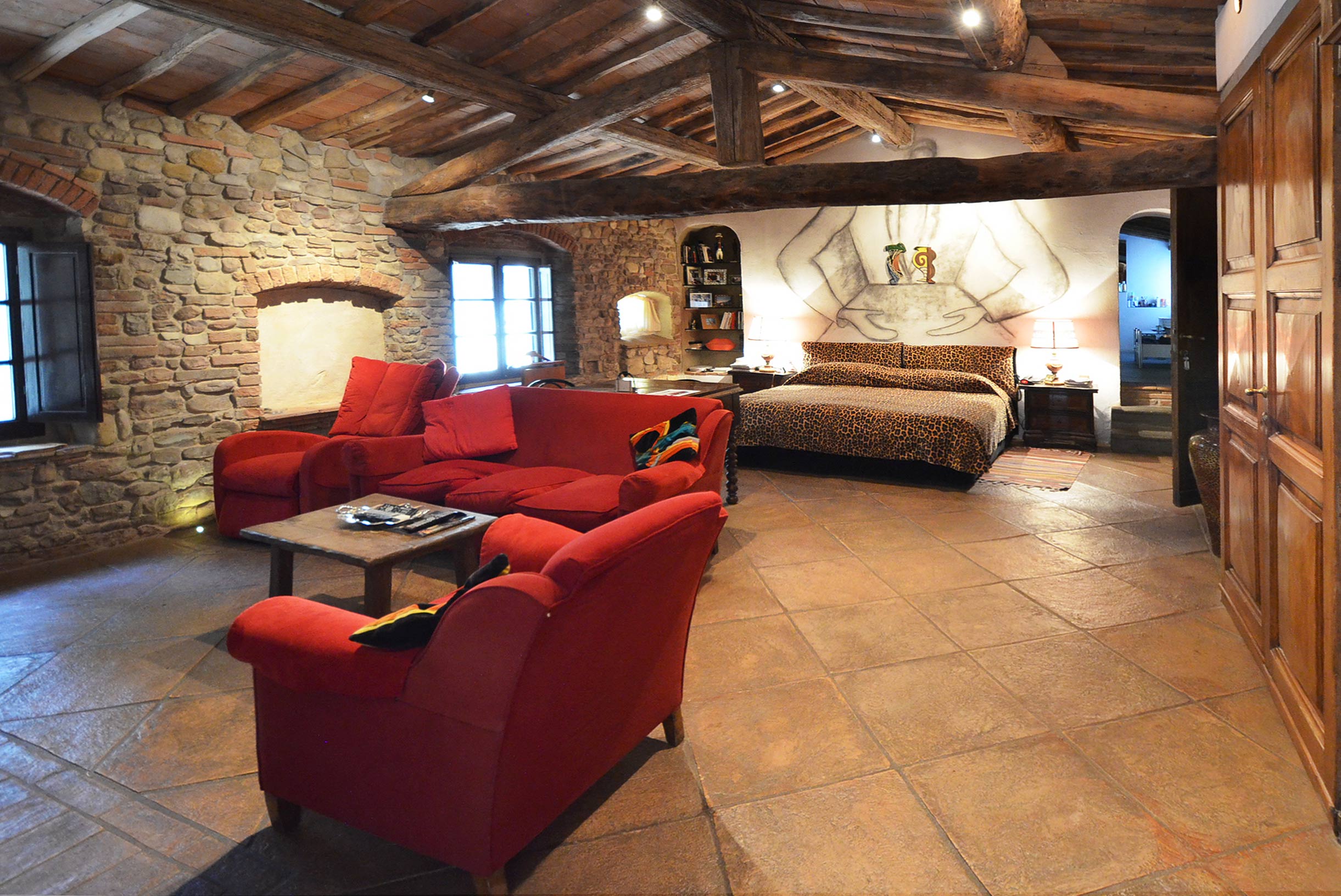 Rustic bedroom with leopard print bedding in Tuscany villa, Fattoria La Corte, Florence