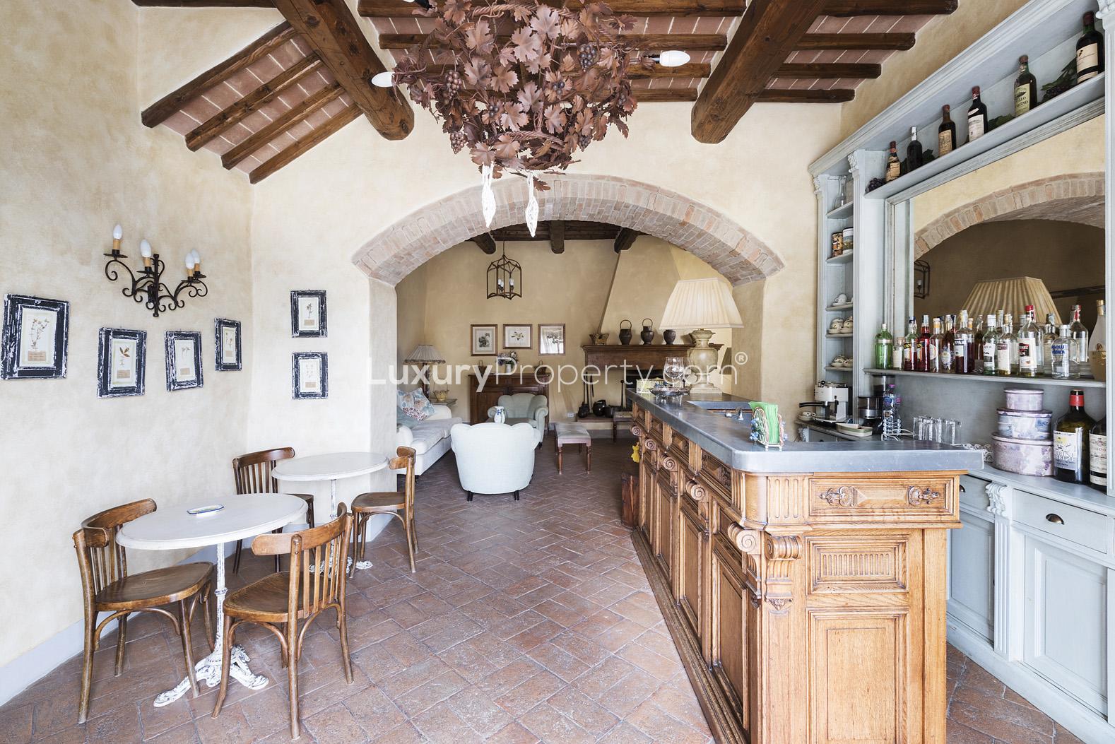 Charming Chianti villa hallway with rustic stone wall and wooden ceiling beams